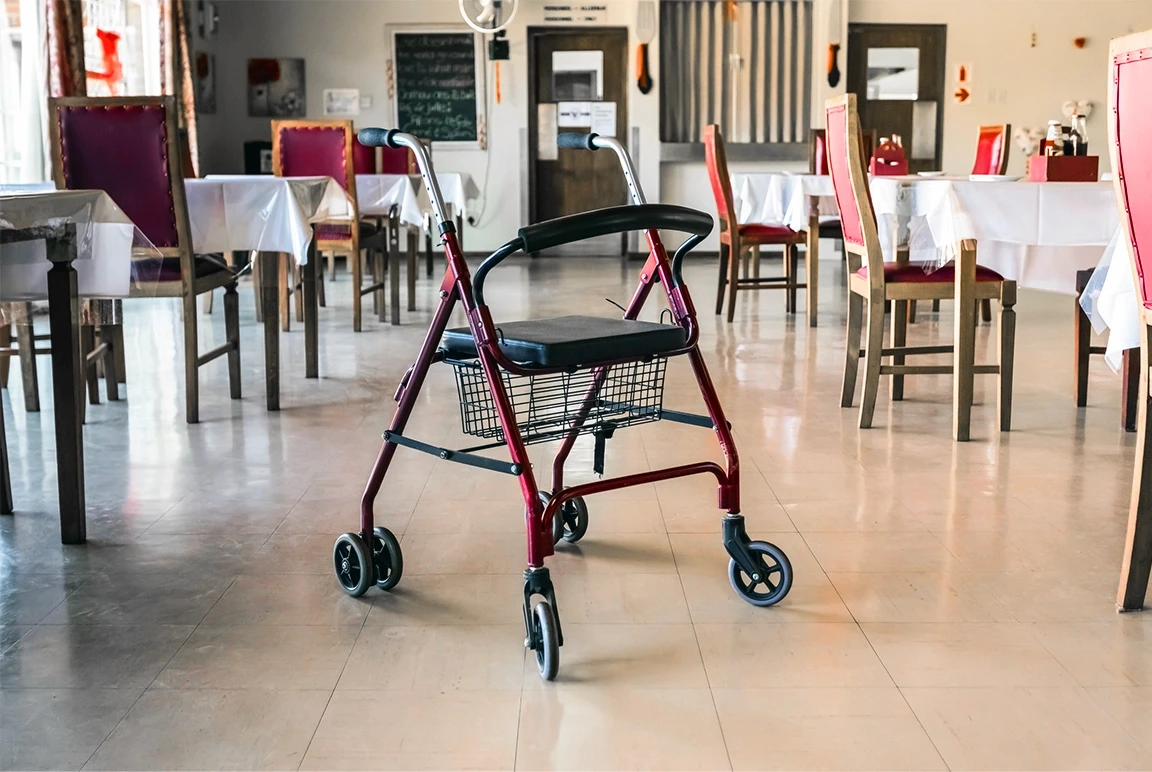 Empty nursing home dining hall with a walking frame in the center, illustrating elder care, supervision, and prevention of neglect or abuse