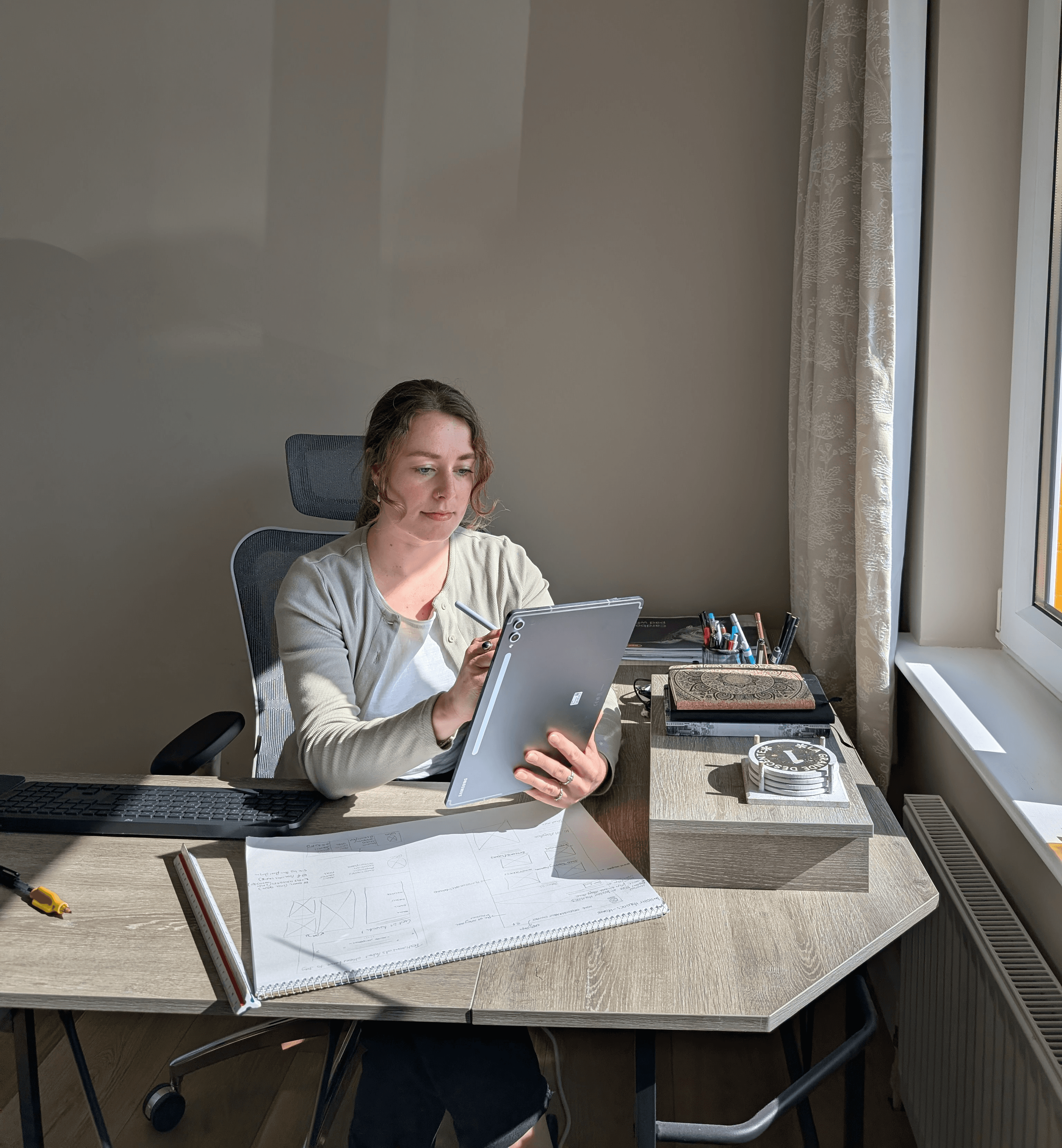 Peak Pixel Design founder Yosta working on a tablet at her desk, symbolising the comprehensive digital blueprint and structured design process for the Professional Studio package.