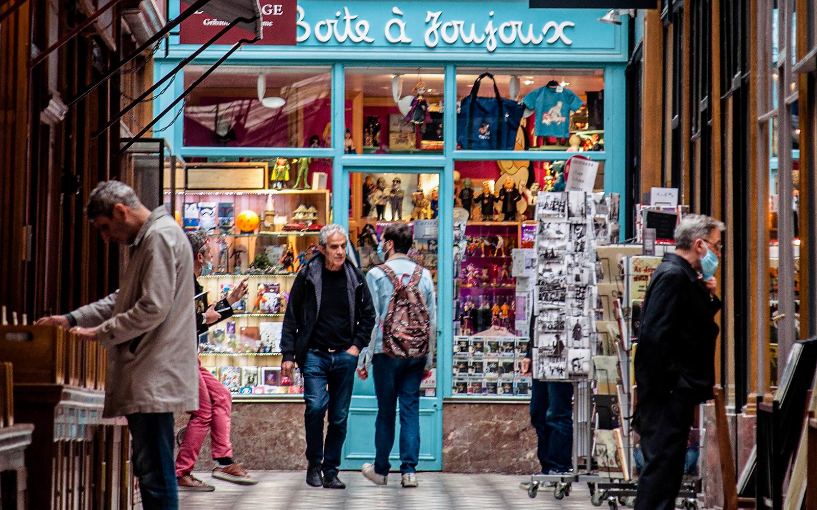 Les consommateurs explorent un magasin de jouets dans une galerie couverte parisienne.
