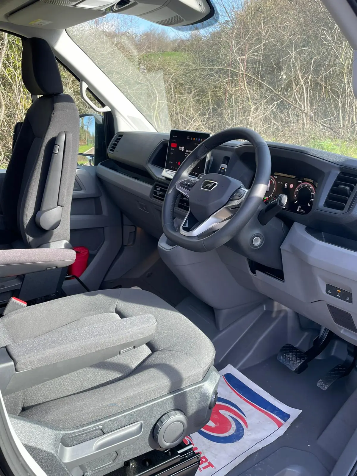 2026 MAN TGE 3.180 interior showing digital dashboard, touchscreen infotainment, and captain's seats