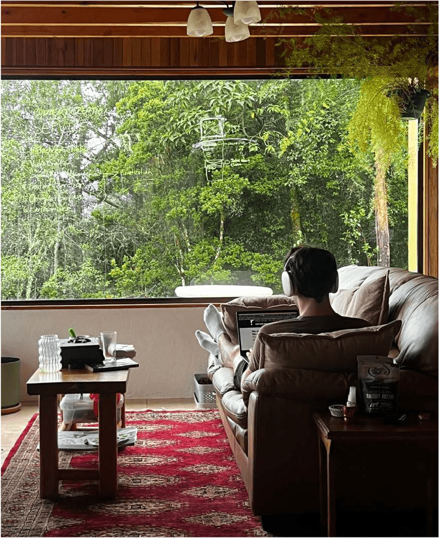 Nicolas, the owner of Buje sits in a couch working on a project. Buje is a social video production company.