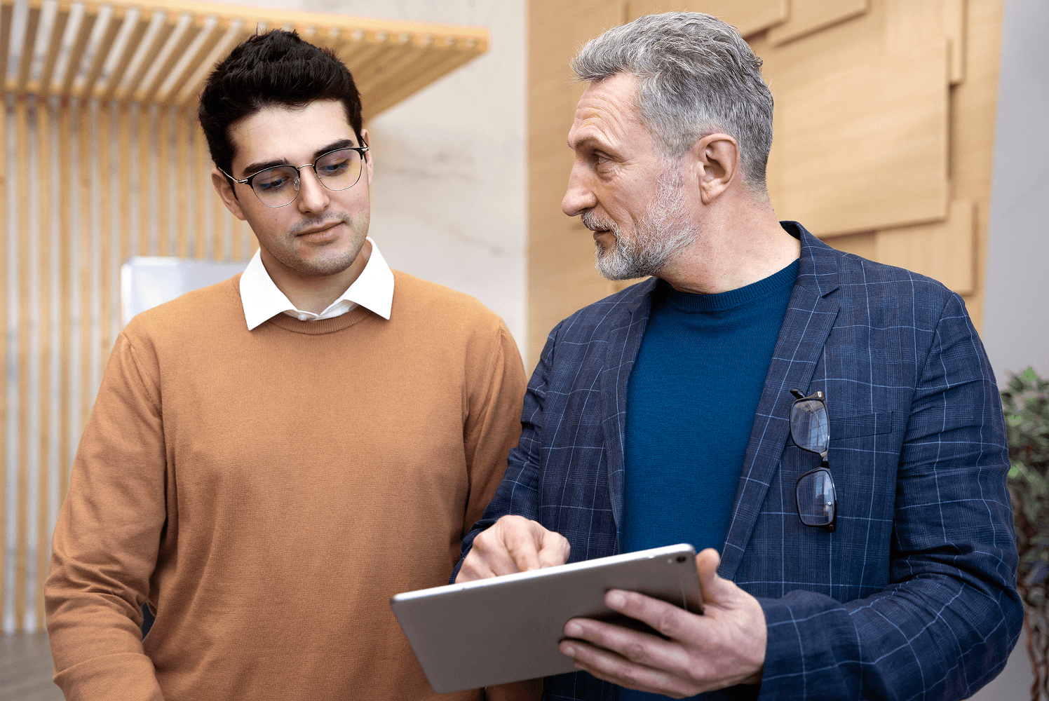 Two men discussing something on a tablet