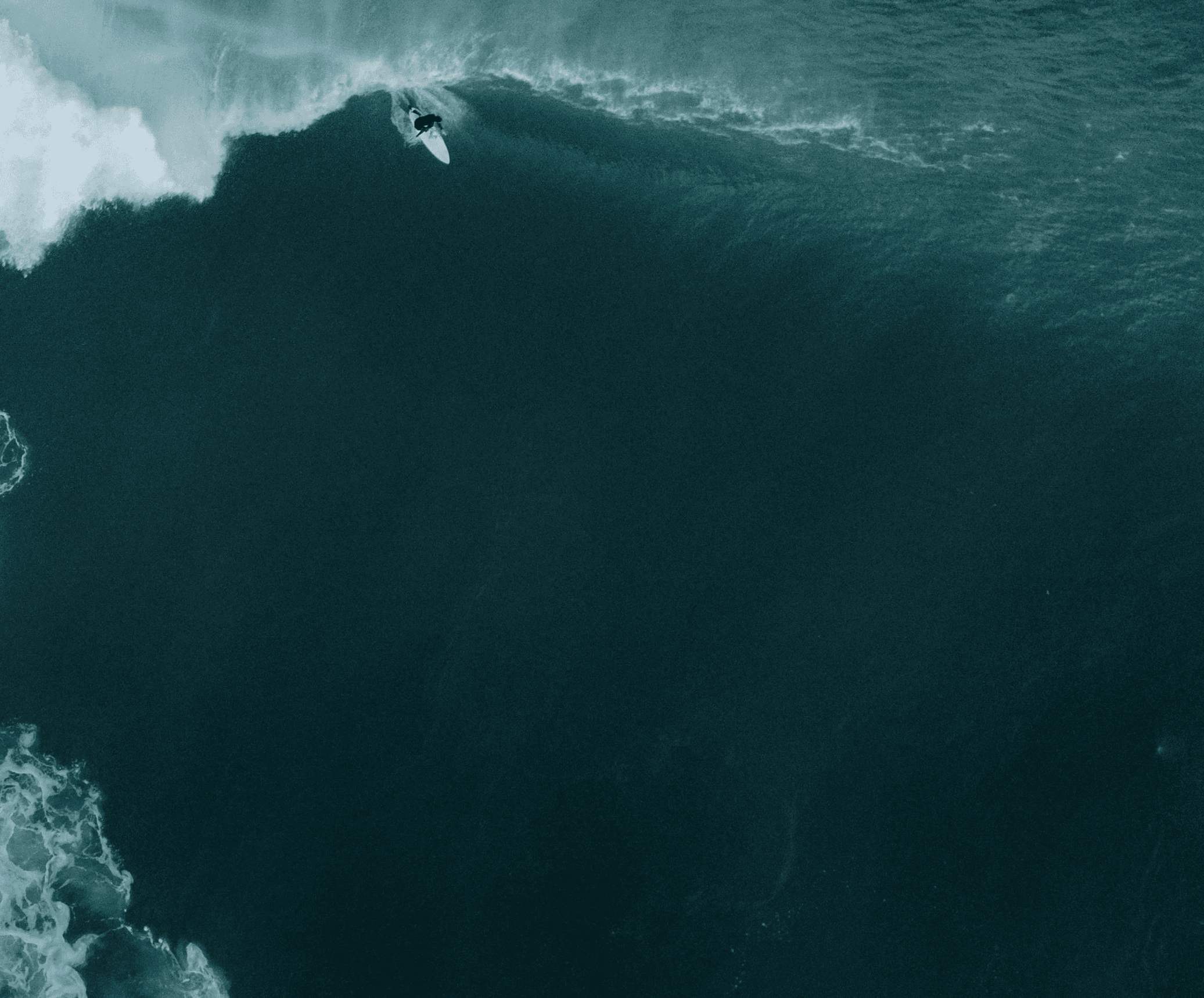 A birds eye view of a surfer riding a wave