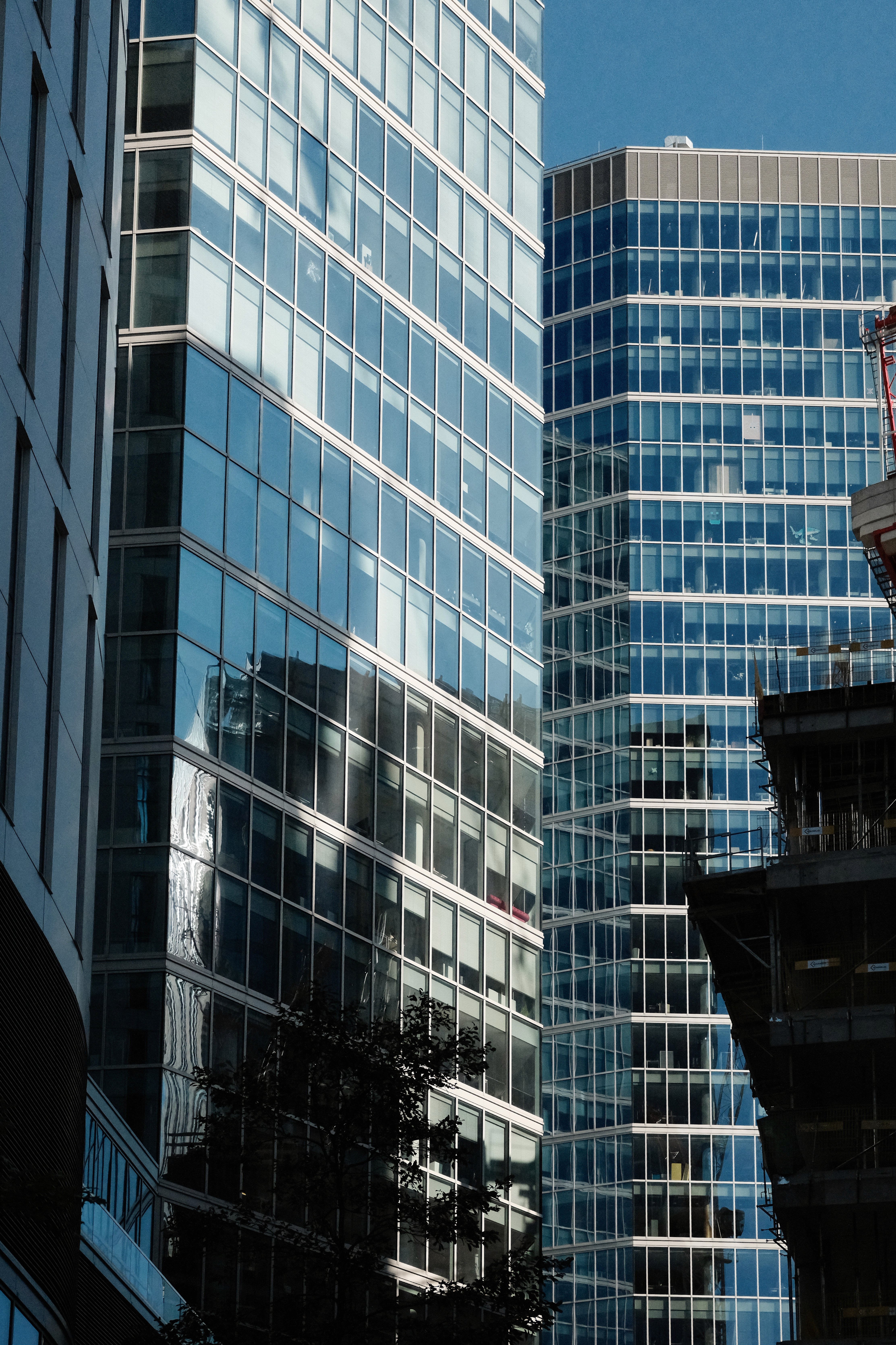 View of modern glass office buildings reflecting the sky in a city setting.