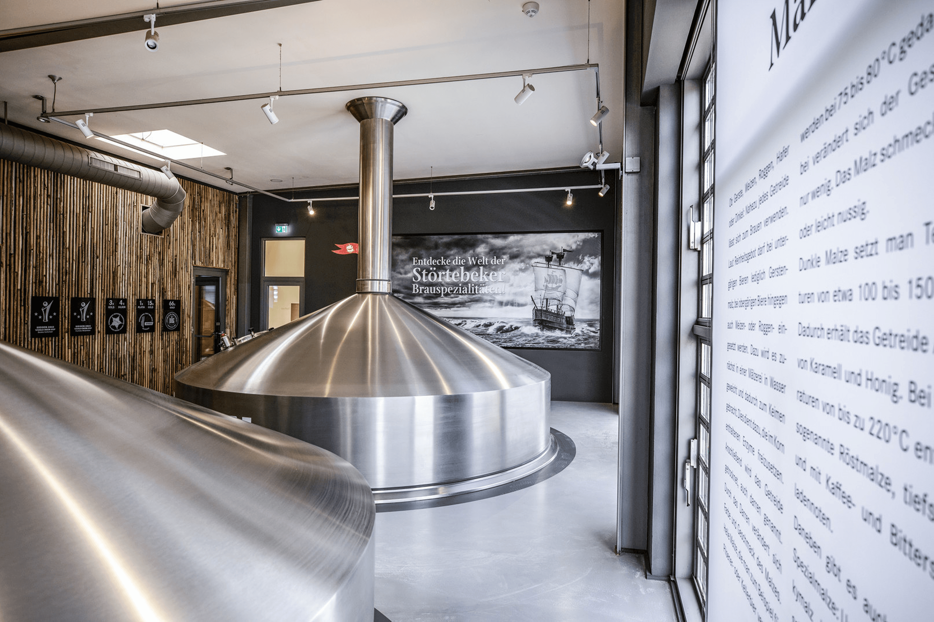 Brewery interior with large stainless steel tanks.