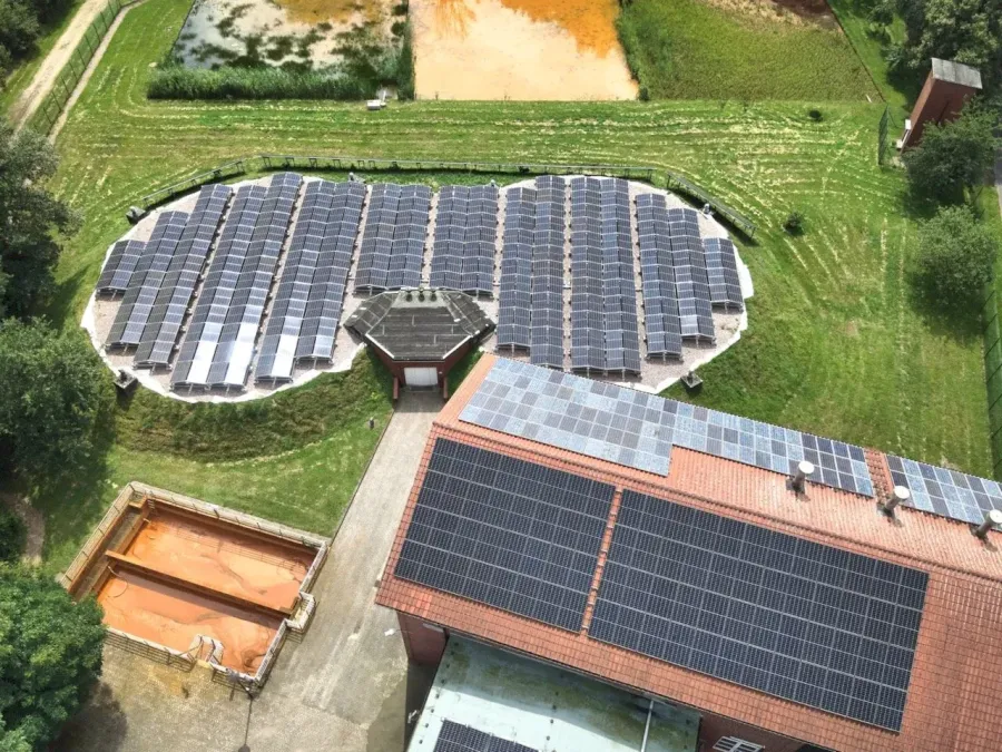 Große Solaranlage mit vielen Panels in kreisförmiger Anordnung und auf einem Dach.