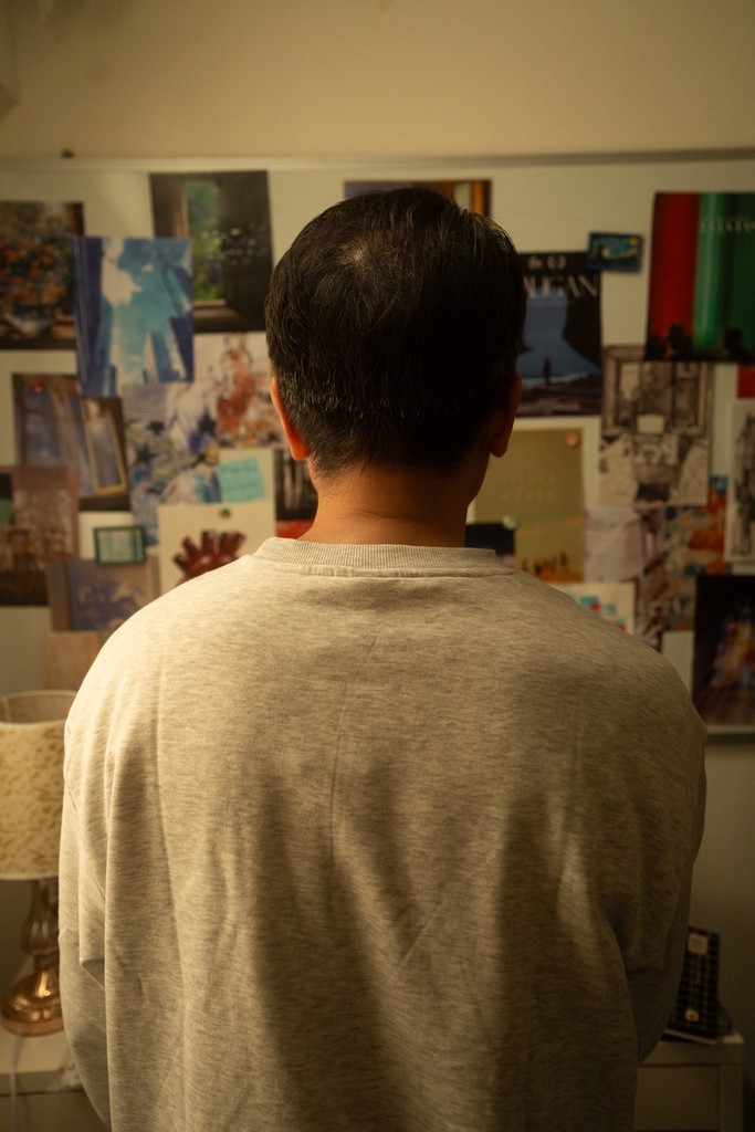 the father looking at his daughter's room and belongings