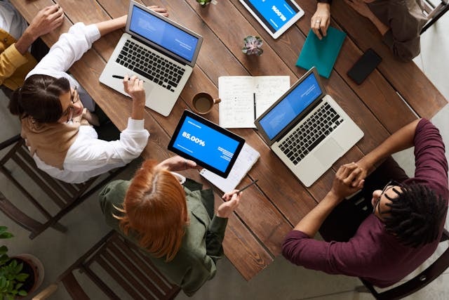 People seated at a table working on their laptops