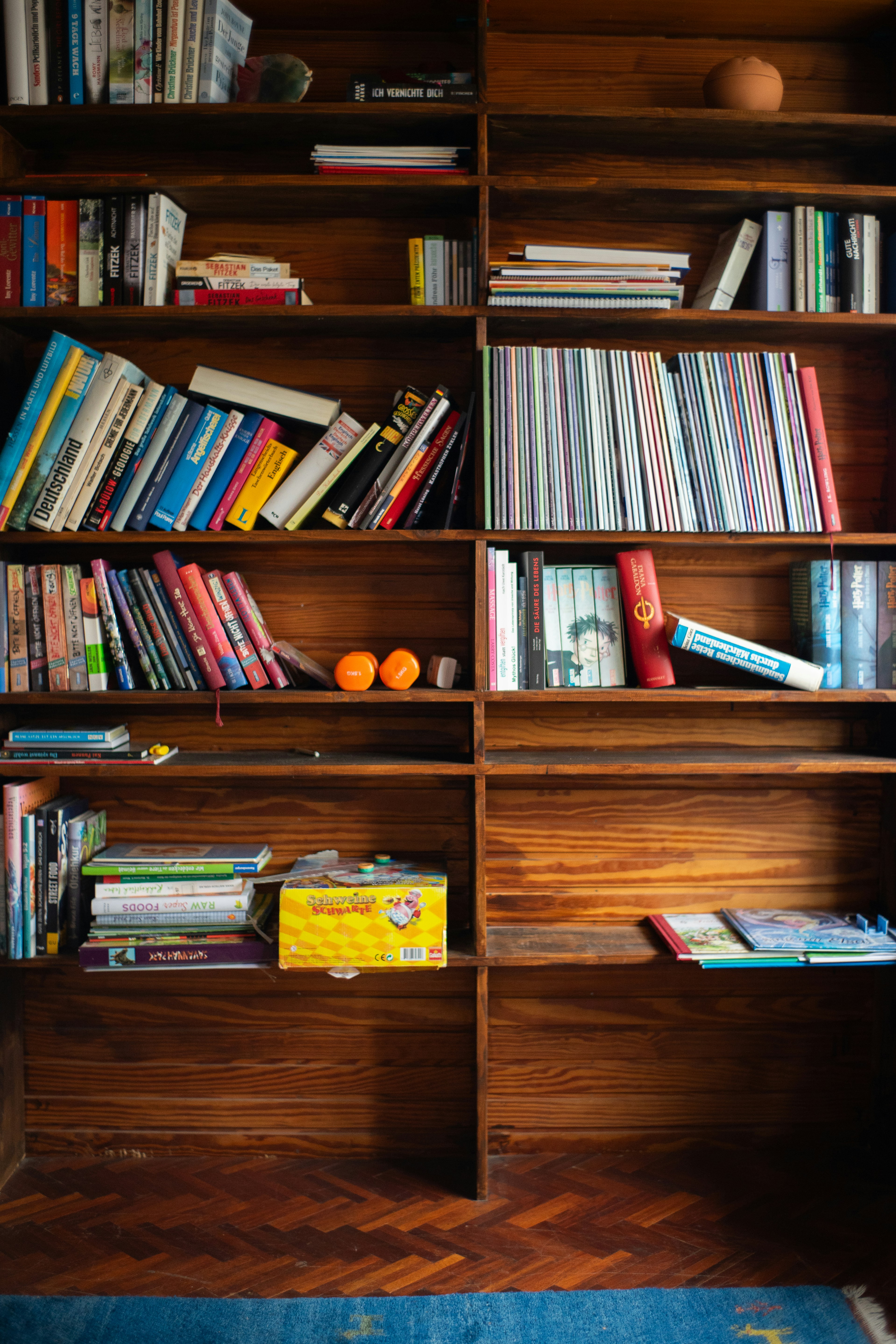 A bookshelf filled with lots of books on top of a wooden floor
