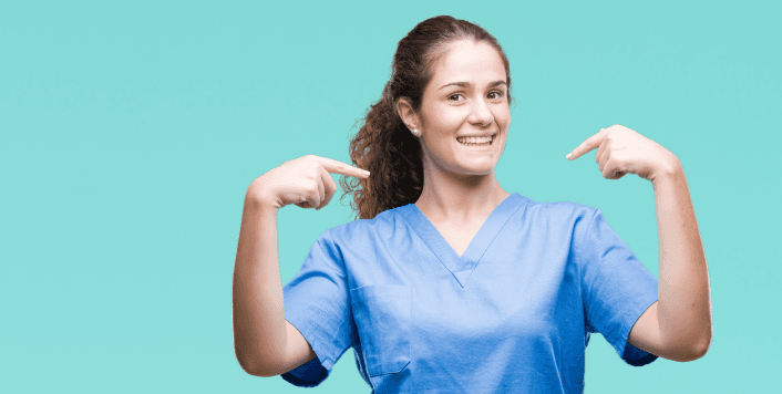 Smiling healthcare worker in scrubs pointing at herself on an aqua background