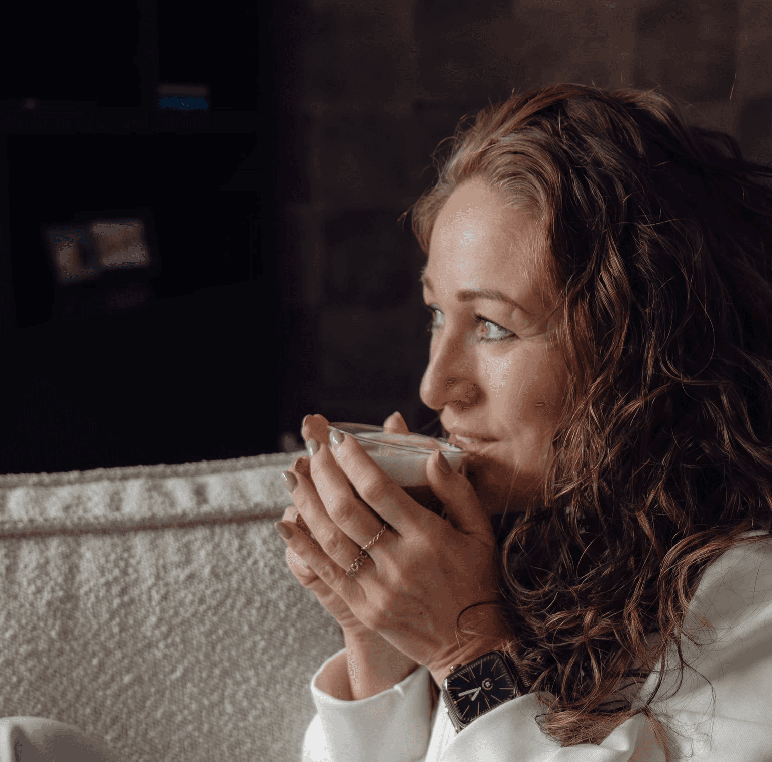 Make A Move Training en Coaching. Vrouw geniet van warme drank op gezellige bank met horloge. 