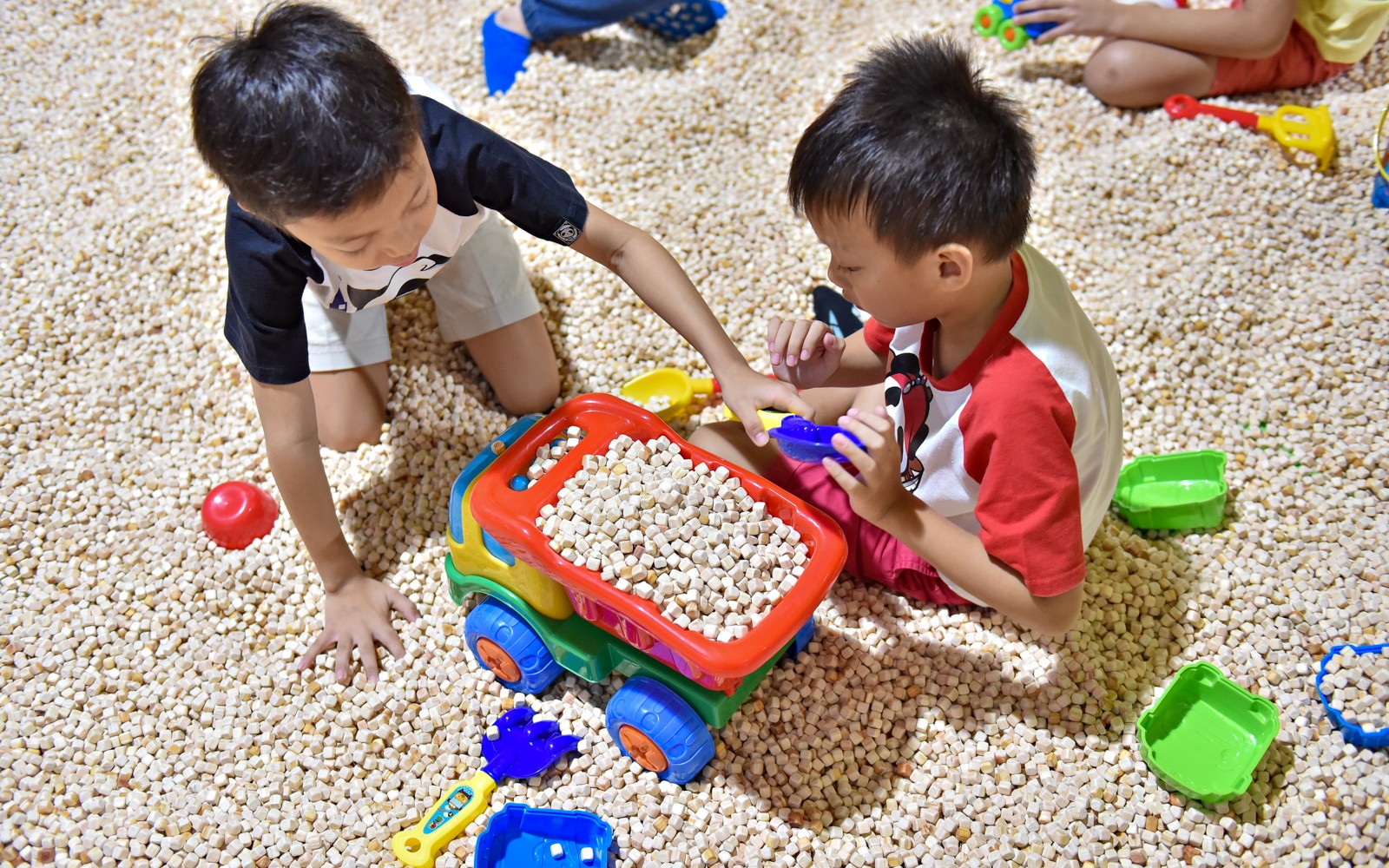 Children playing with toy truck at Tayo Station indoor playground.