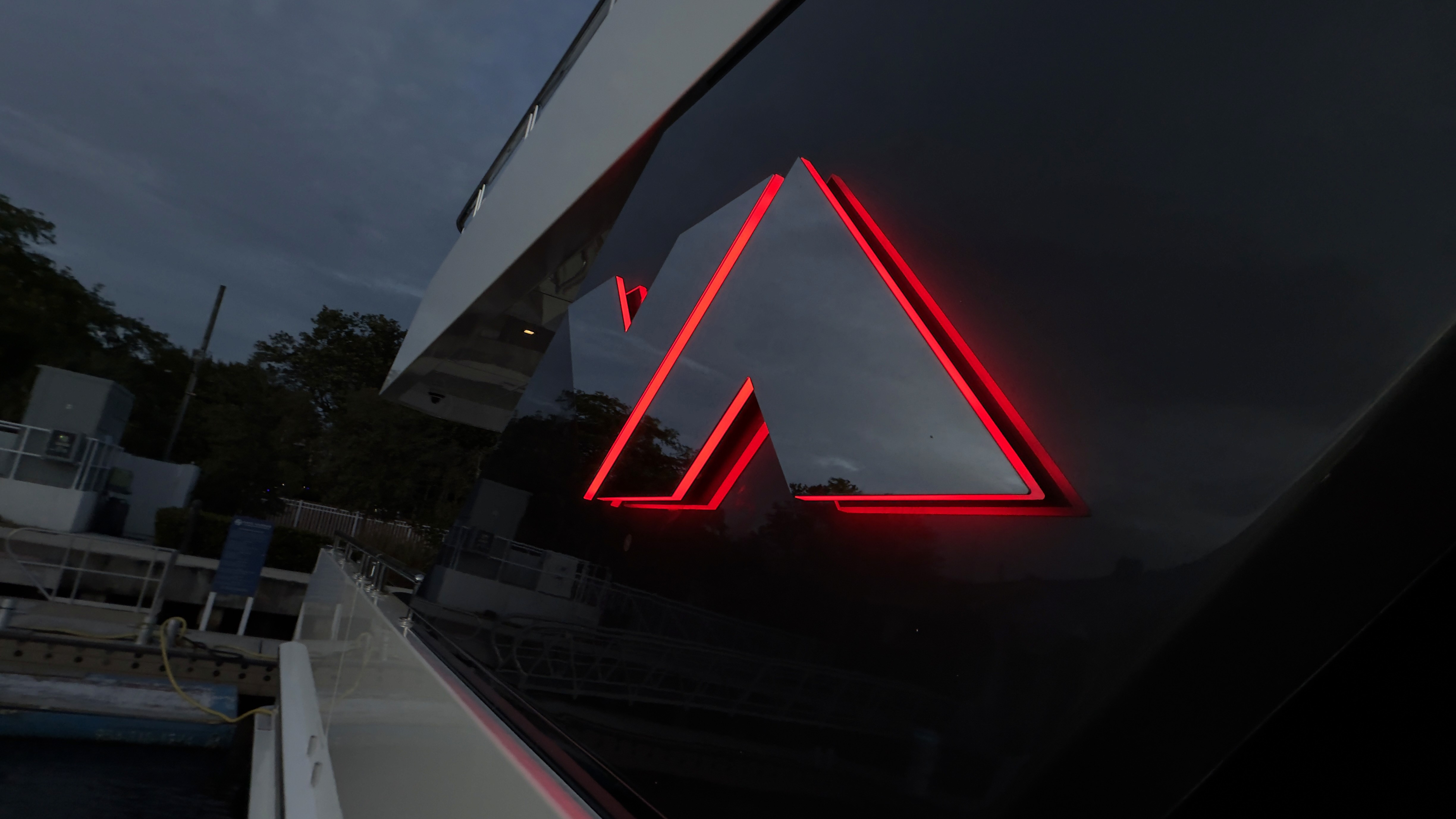 Custom red LED illuminated yacht lettering viewed from deck at dusk