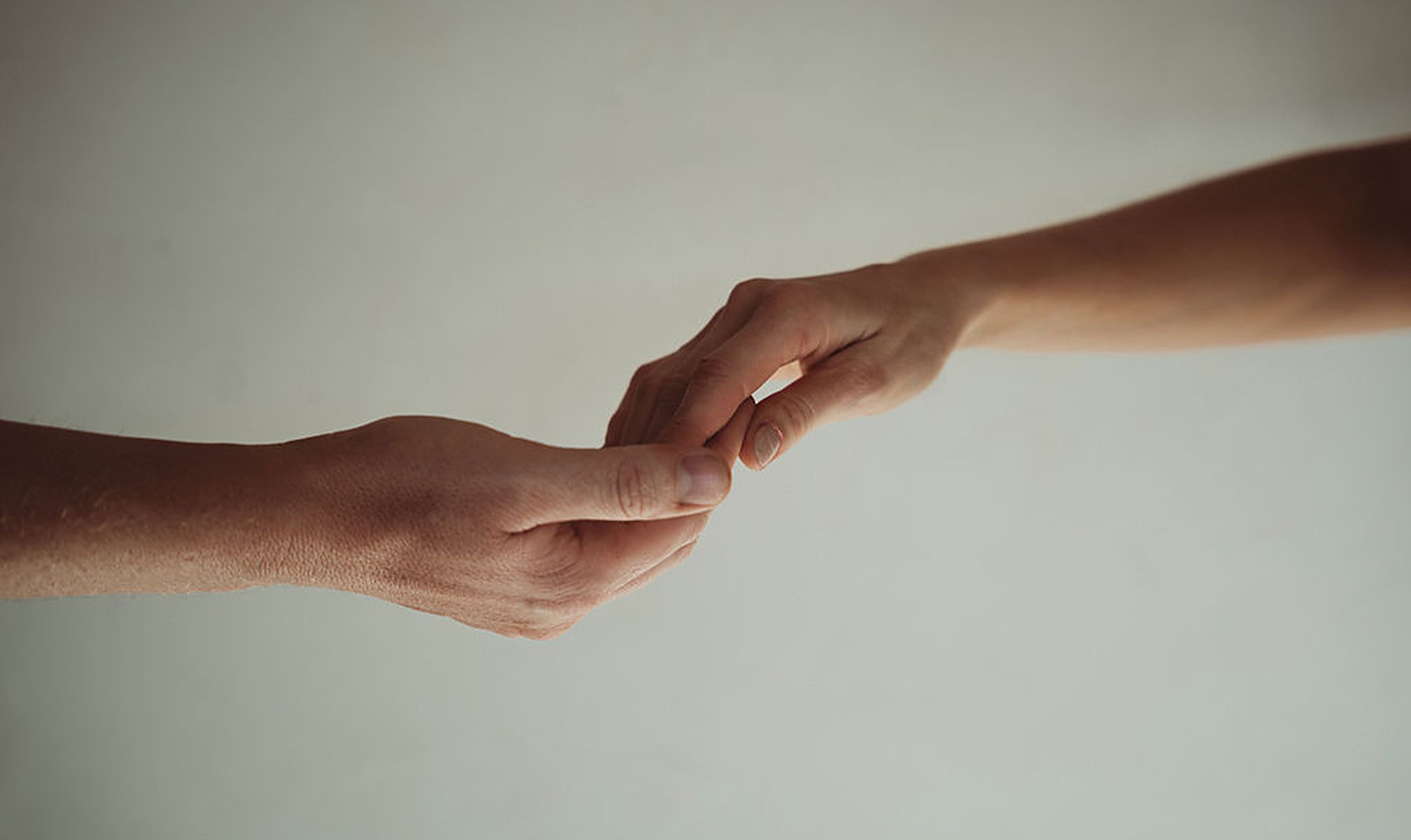 Two hands reaching for each other, the everyday closeness that sparks desire in a long-term relationship