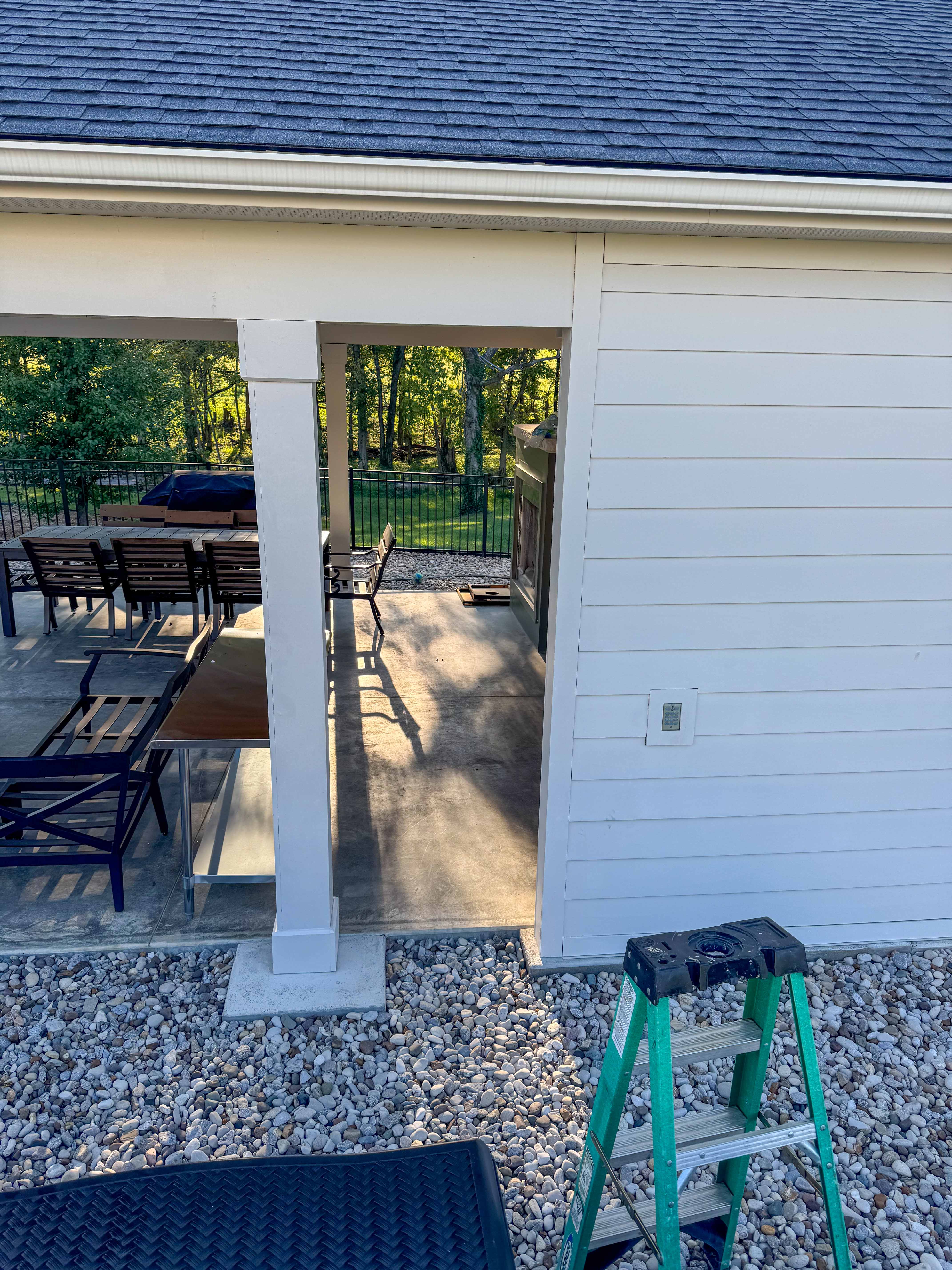 Outdoor structure construction with metal fencing and stone base