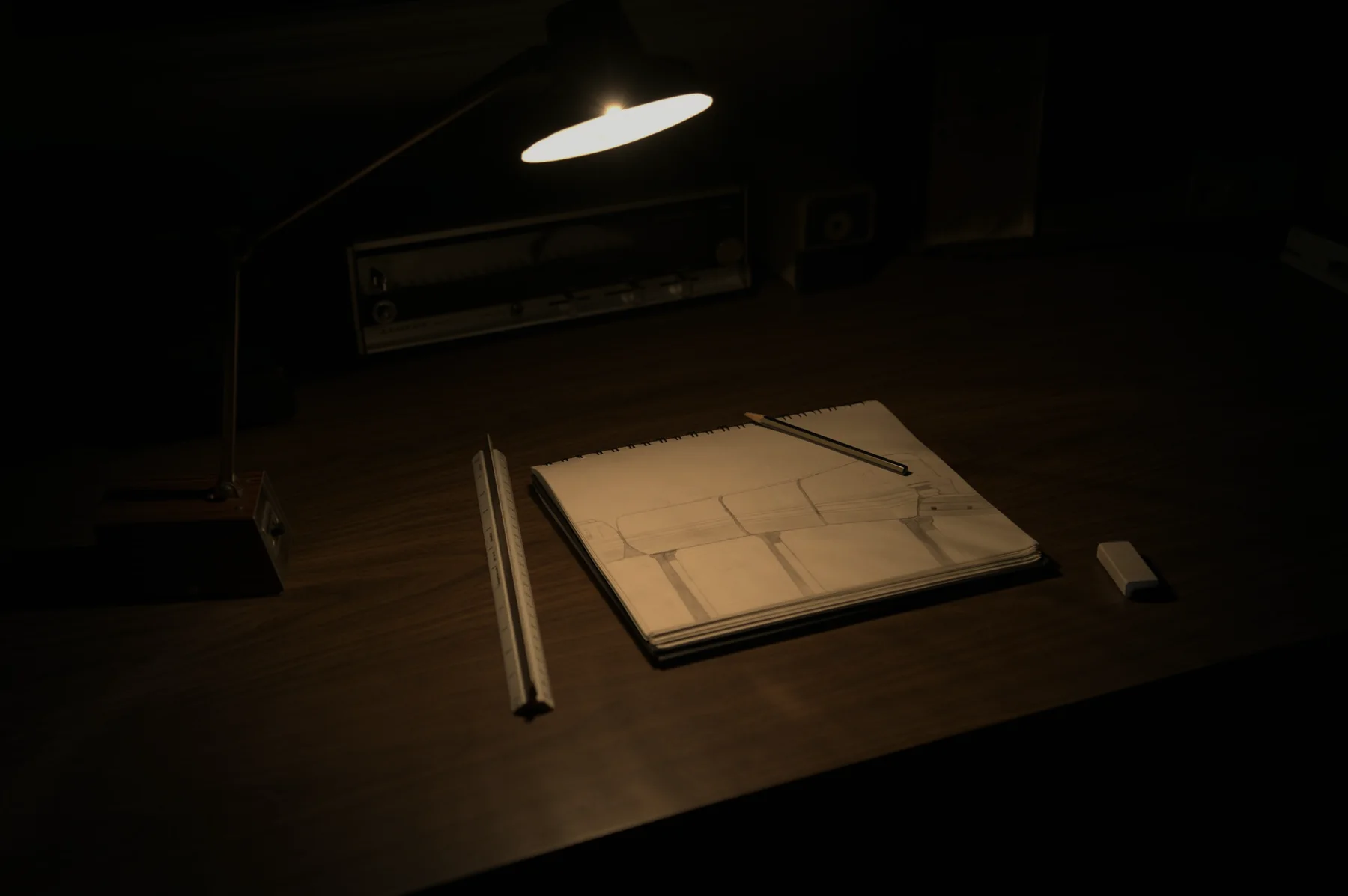 A desk with a lamp and an open sketchbook