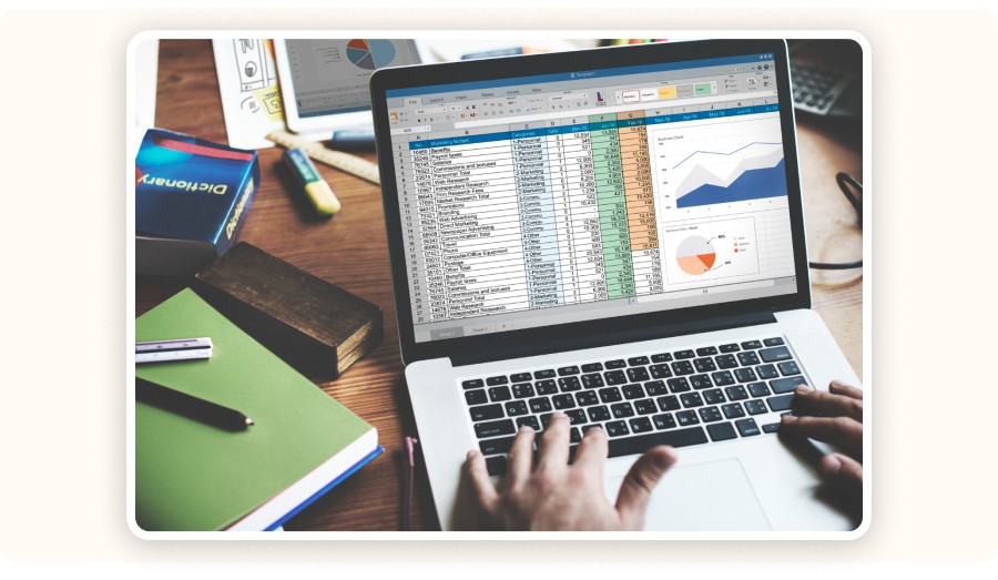 Personne travaillant sur ordinateur portable avec tableau données et graphiques.