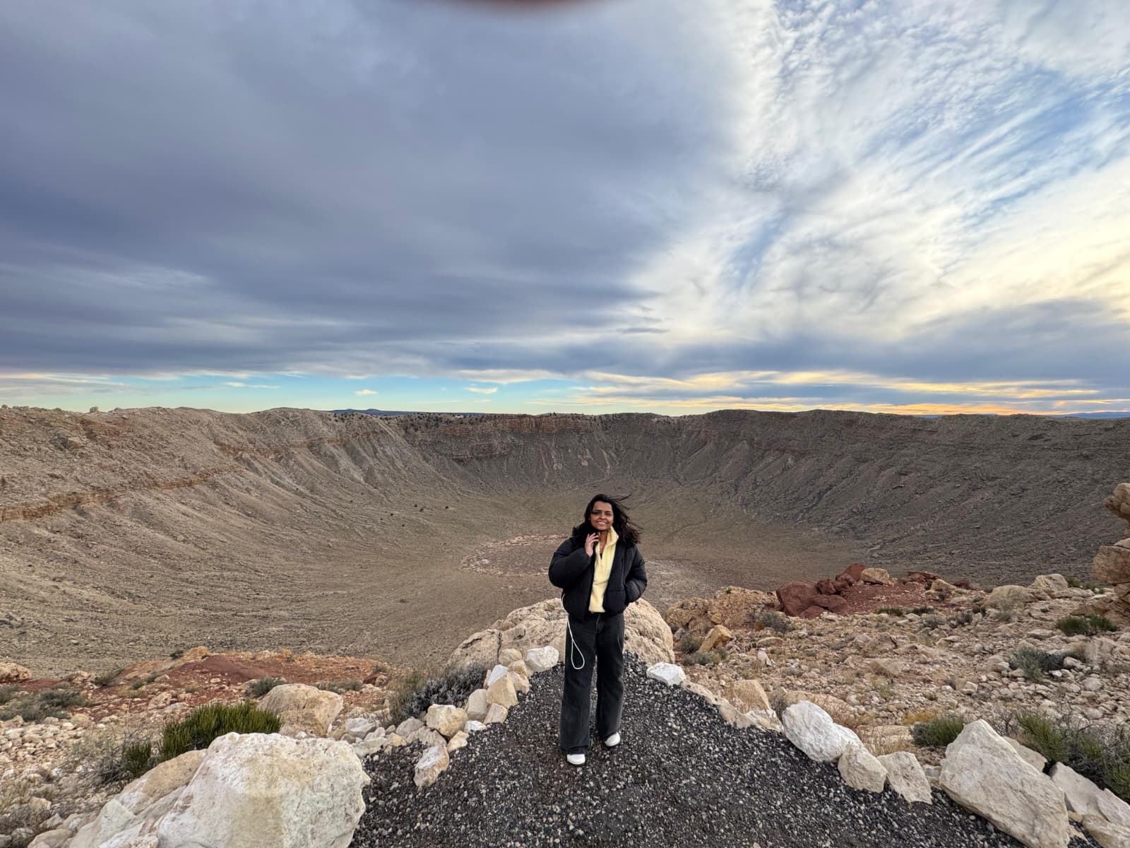 Man crouching with mountains in background