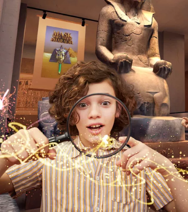 A young explorer holding a magnifying glass with magical golden sparkles, standing in front of an ancient Egyptian statue inside a virtual museum or tomb.
