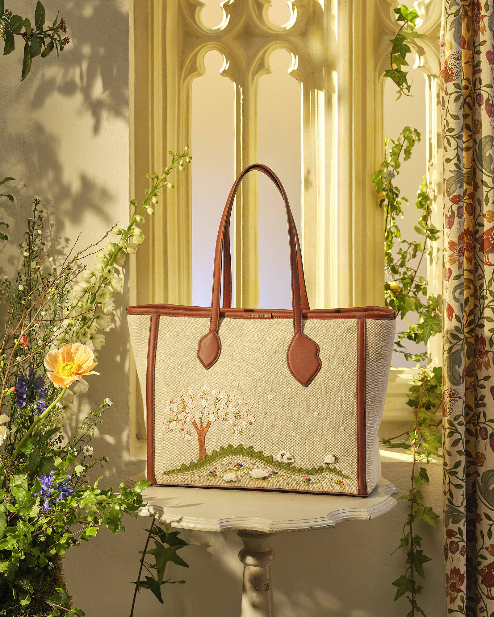 Elegant embroidered handbag with nature design in sunlit room.