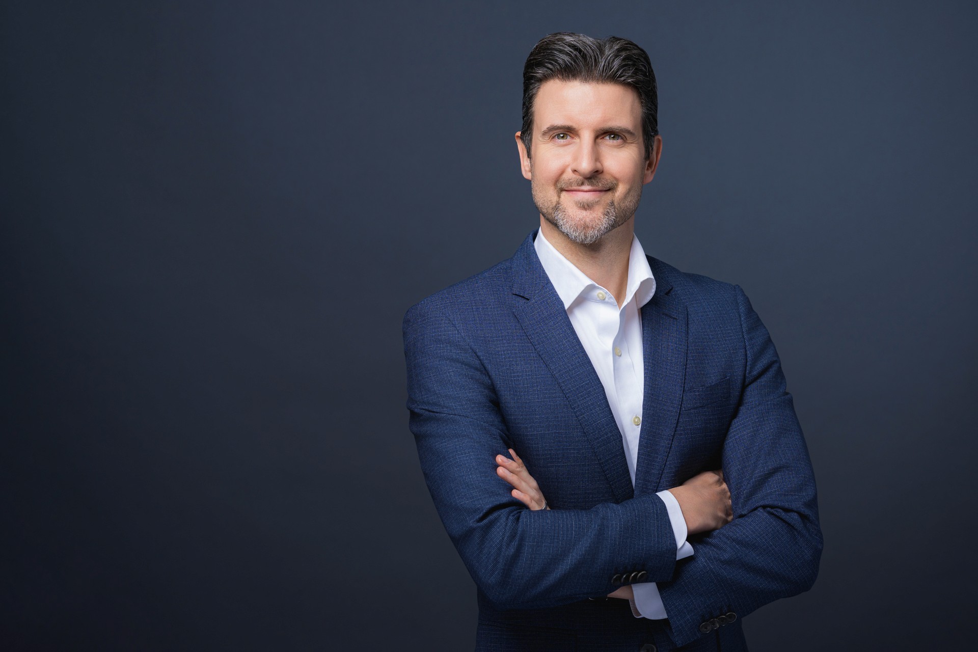 Professionelles Bewerbungsfoto eines Mannes im blauen Anzug, Business Portrait aus Zürich mit neutralem Hintergrund.