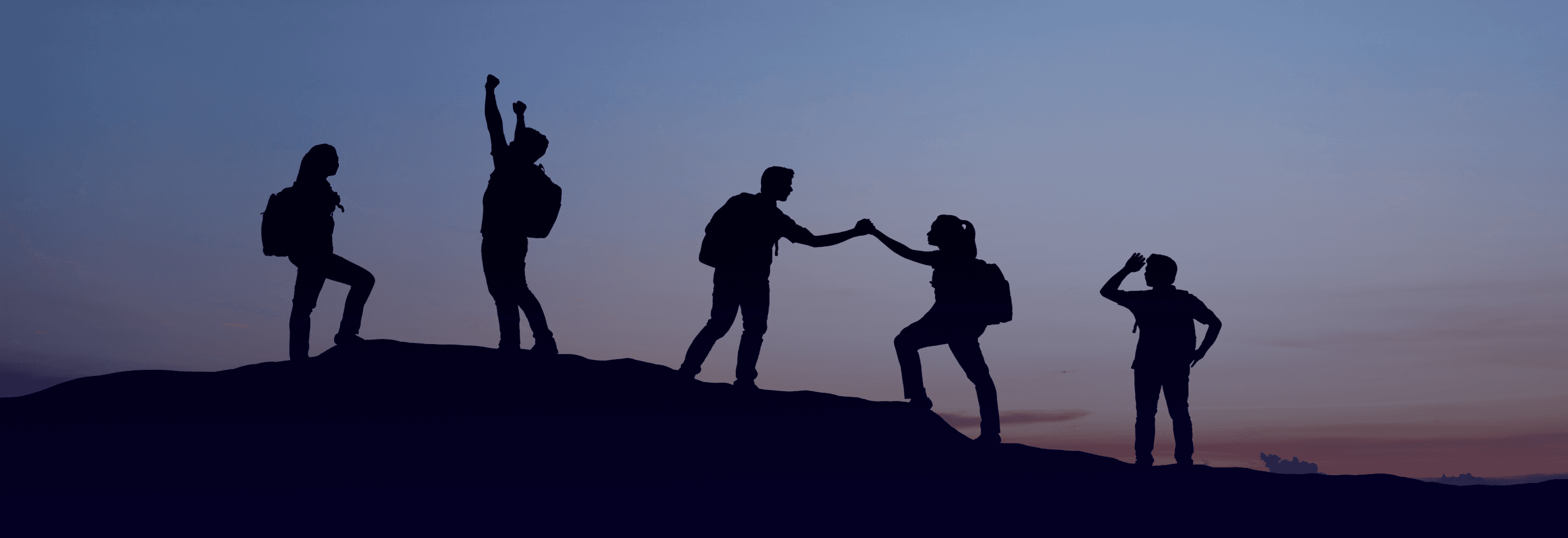 SIlhouette of people cheering on top of a mountain