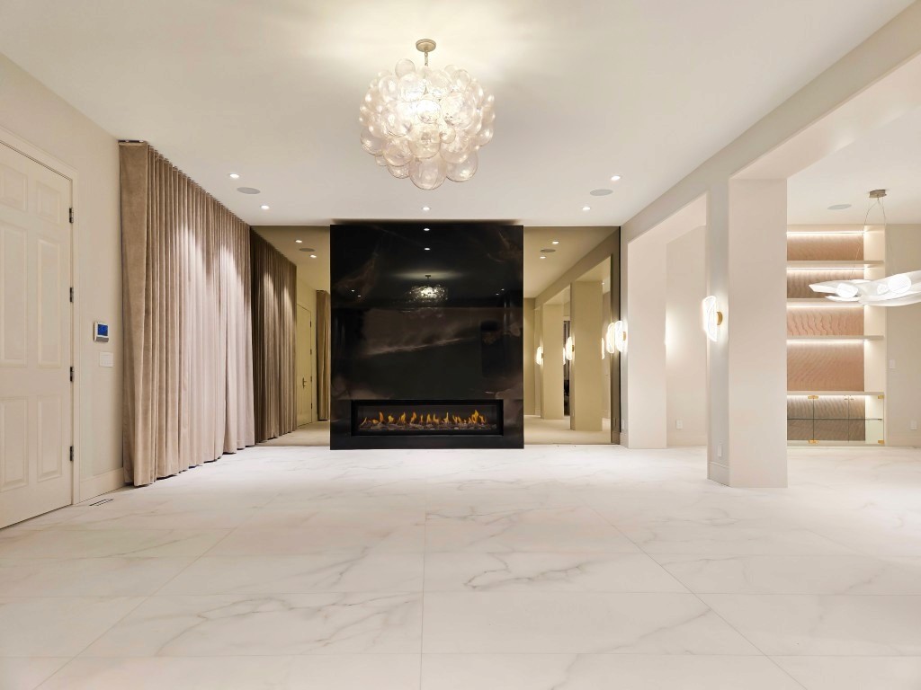 Image of Luxury interior design featuring marble floors, modern chandelier, and sleek fireplace in a KHD Homes renovation.