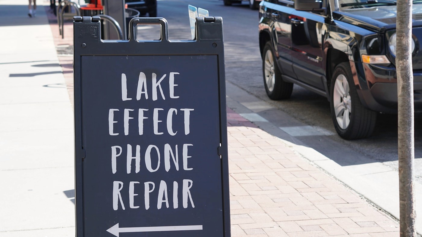 Local storefront sign on a city sidewalk