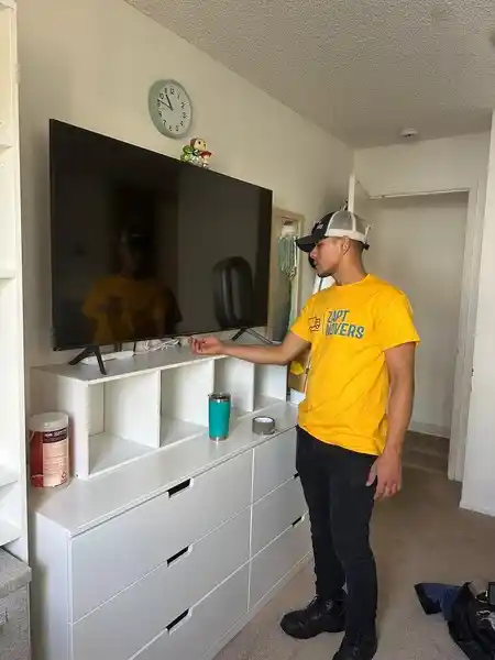 Zapt Movers professional mounting a TV during move-in setup