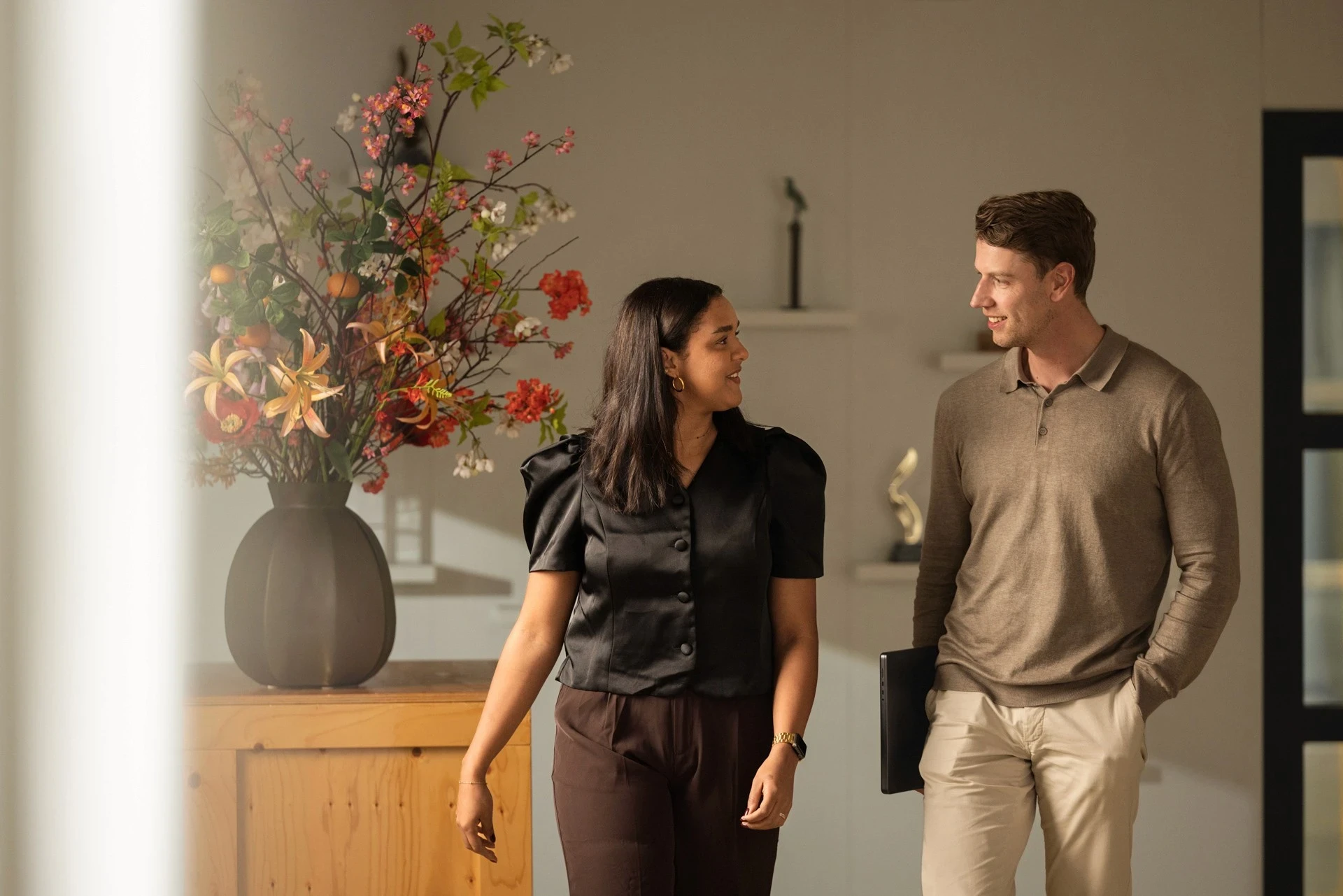 Smiling woman and man chat indoors.