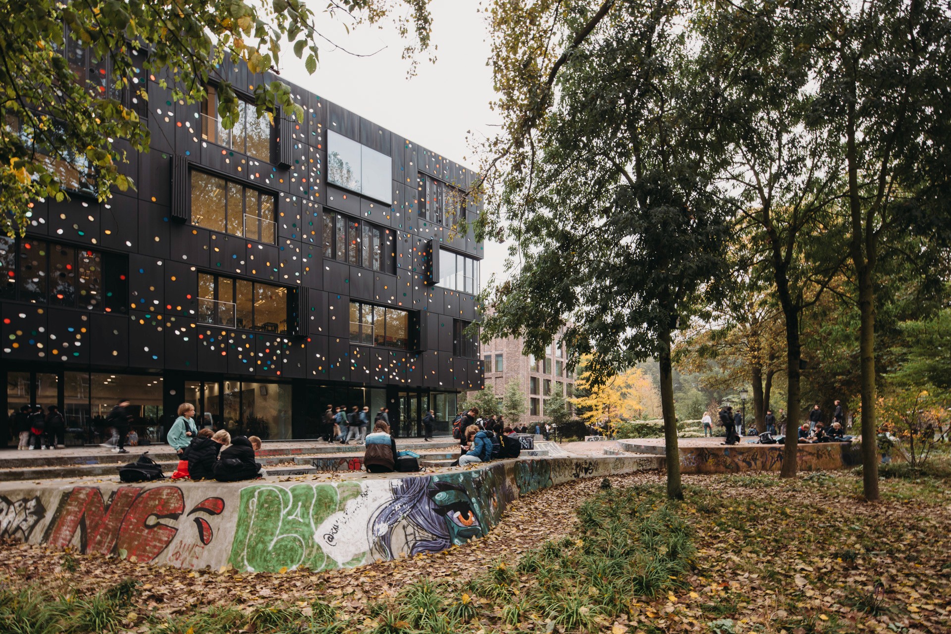 Photo of the exterior of the Metis Montessori Lyceum seen from the Oosterpark, with the skateramp just in front of the building