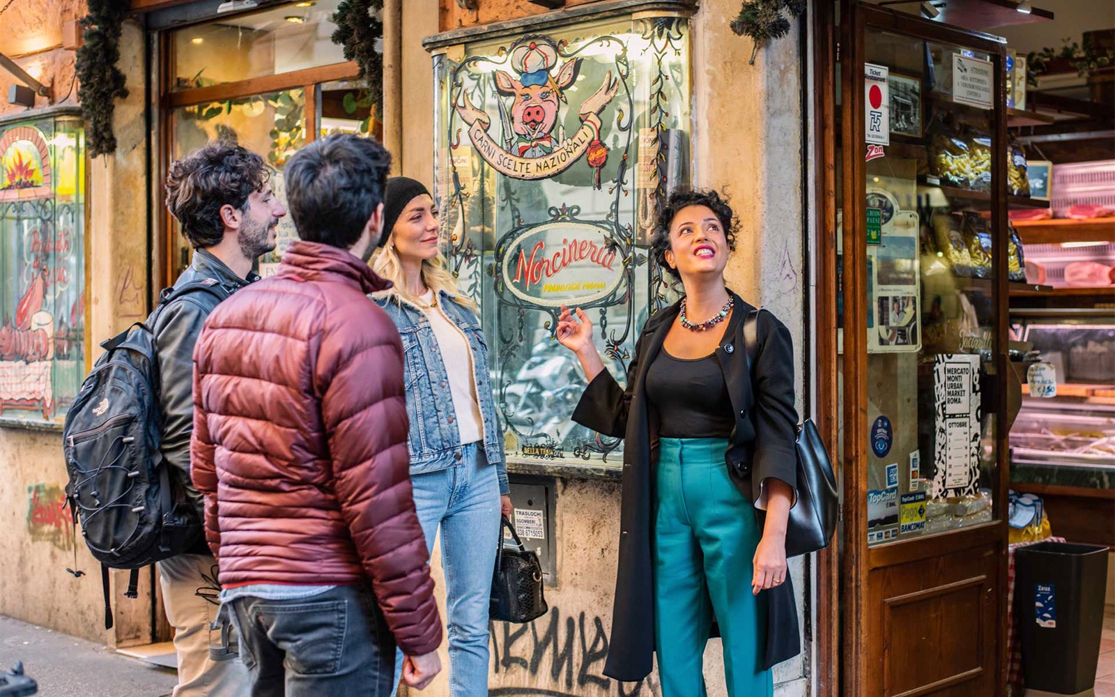 Rondleider met een groep buiten een delicatessenwinkel in Trastevere tijdens een culinaire en wijntour.