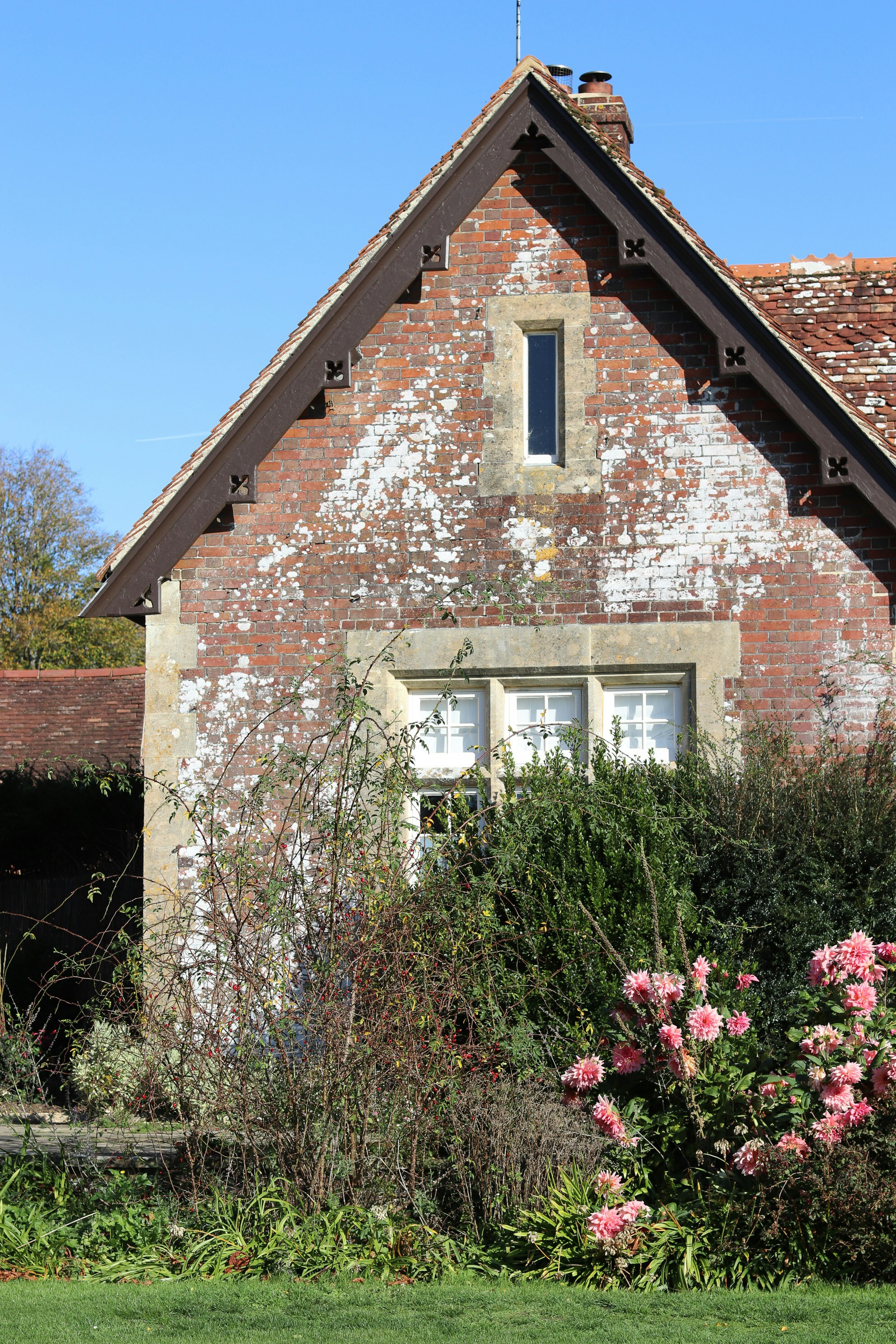 Brick building with a pitched roof and garden.