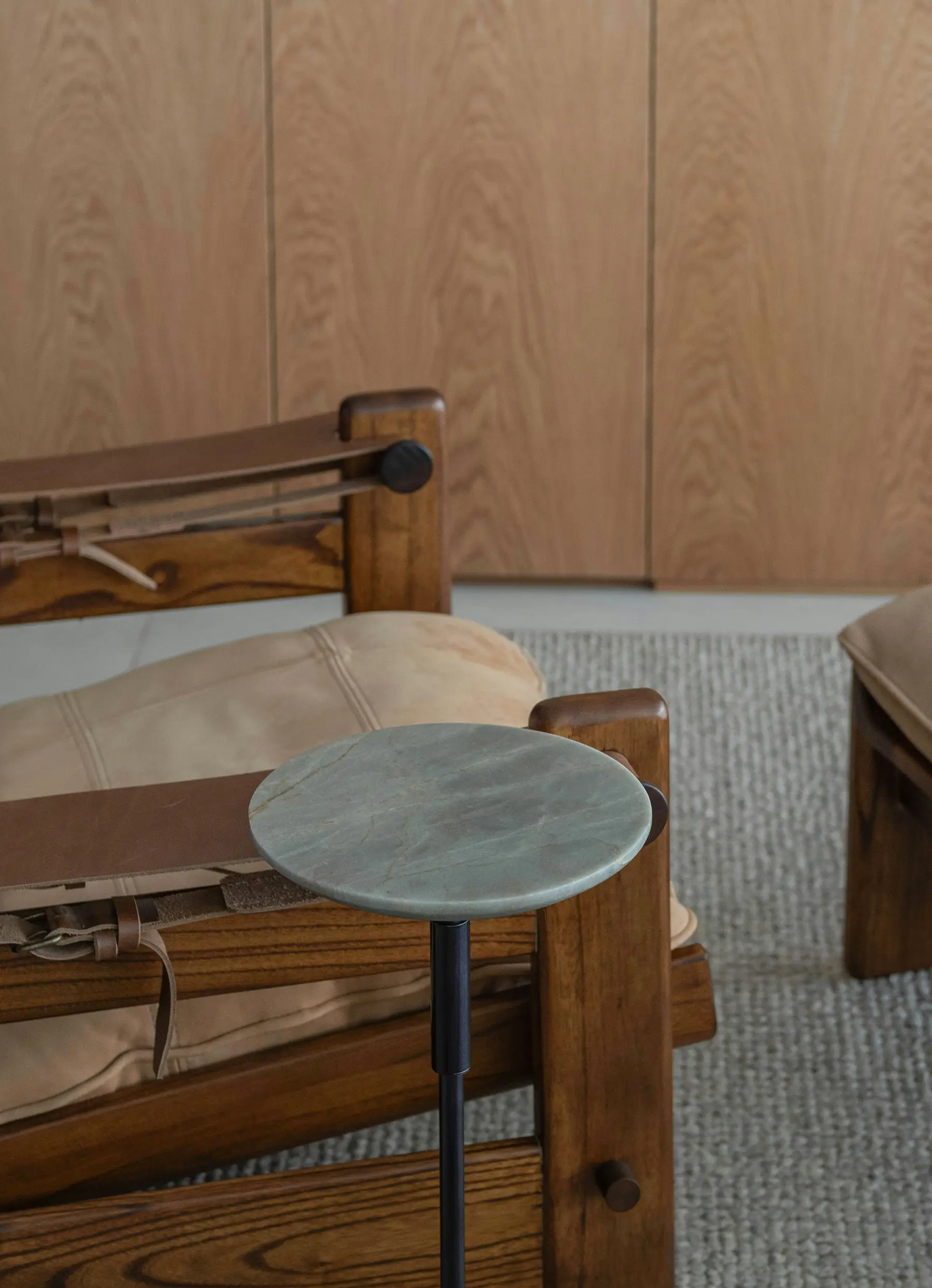 Round marble table next to a wooden chair.