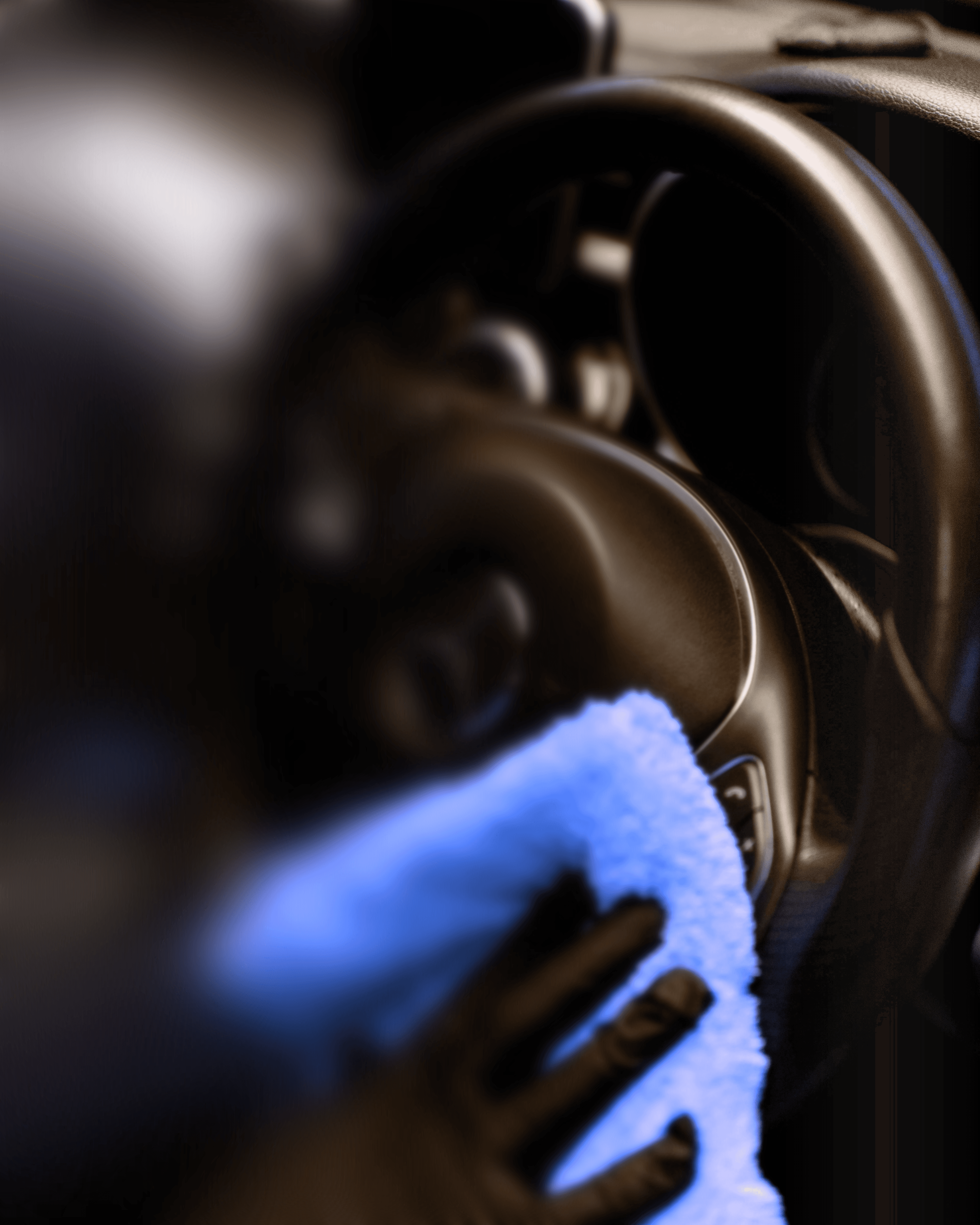 A person cleaning a car with a yellow cloth