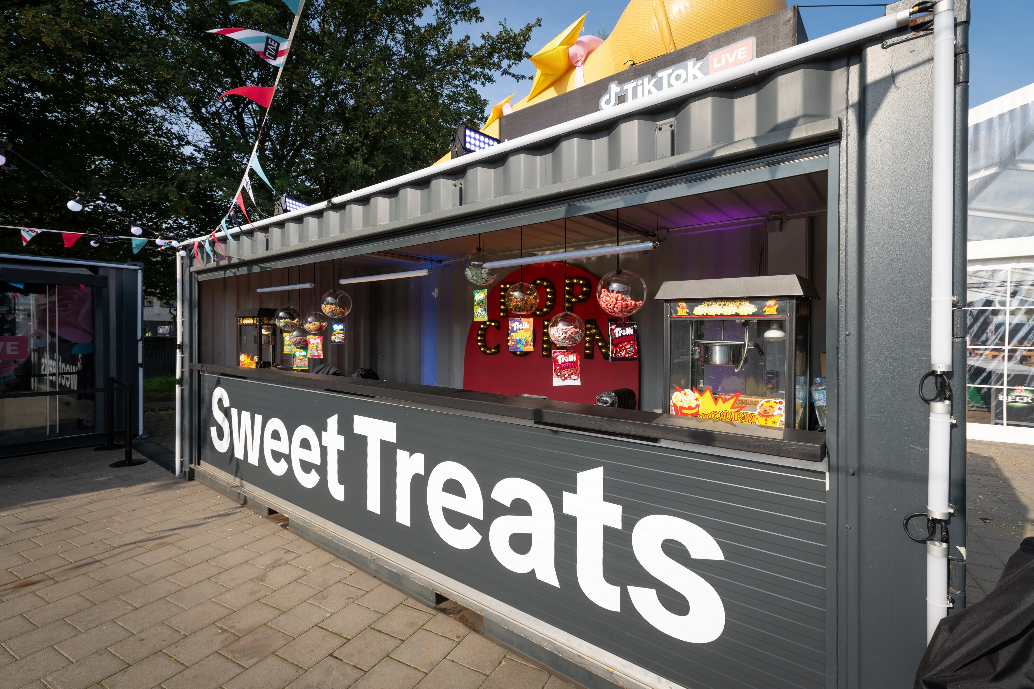 Sweet Treats container counter with candy dispensers, popcorn machine and illuminated lettering.
