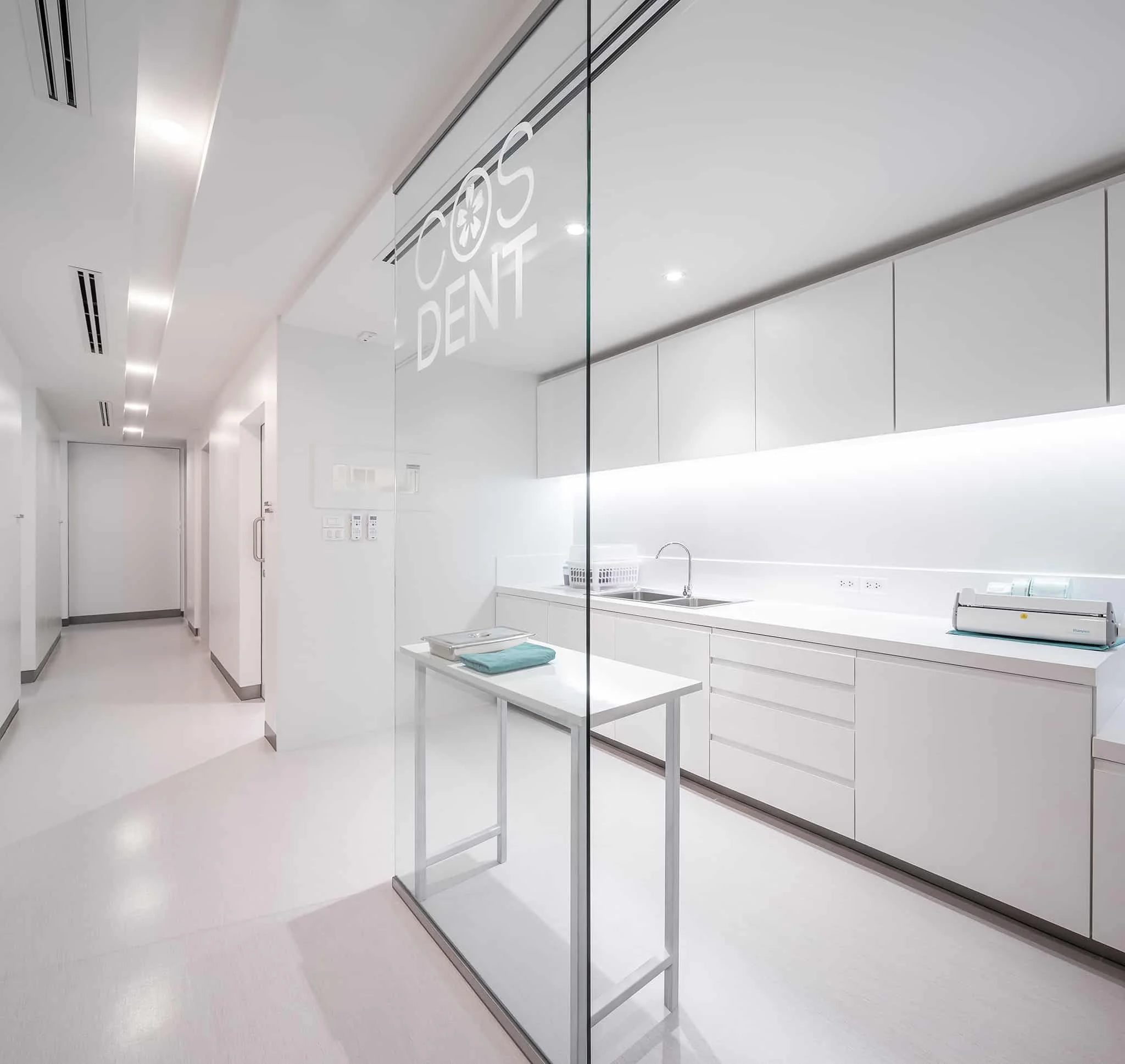 Sterilisation area behind glass, with the COSDENT logo etched on the panel