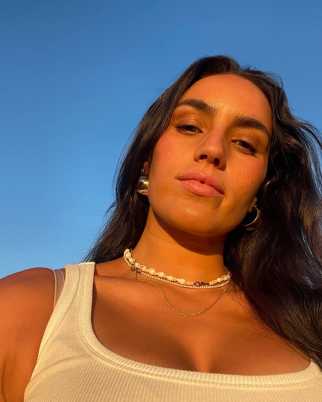 Black cosmetic product bottle against a dark background