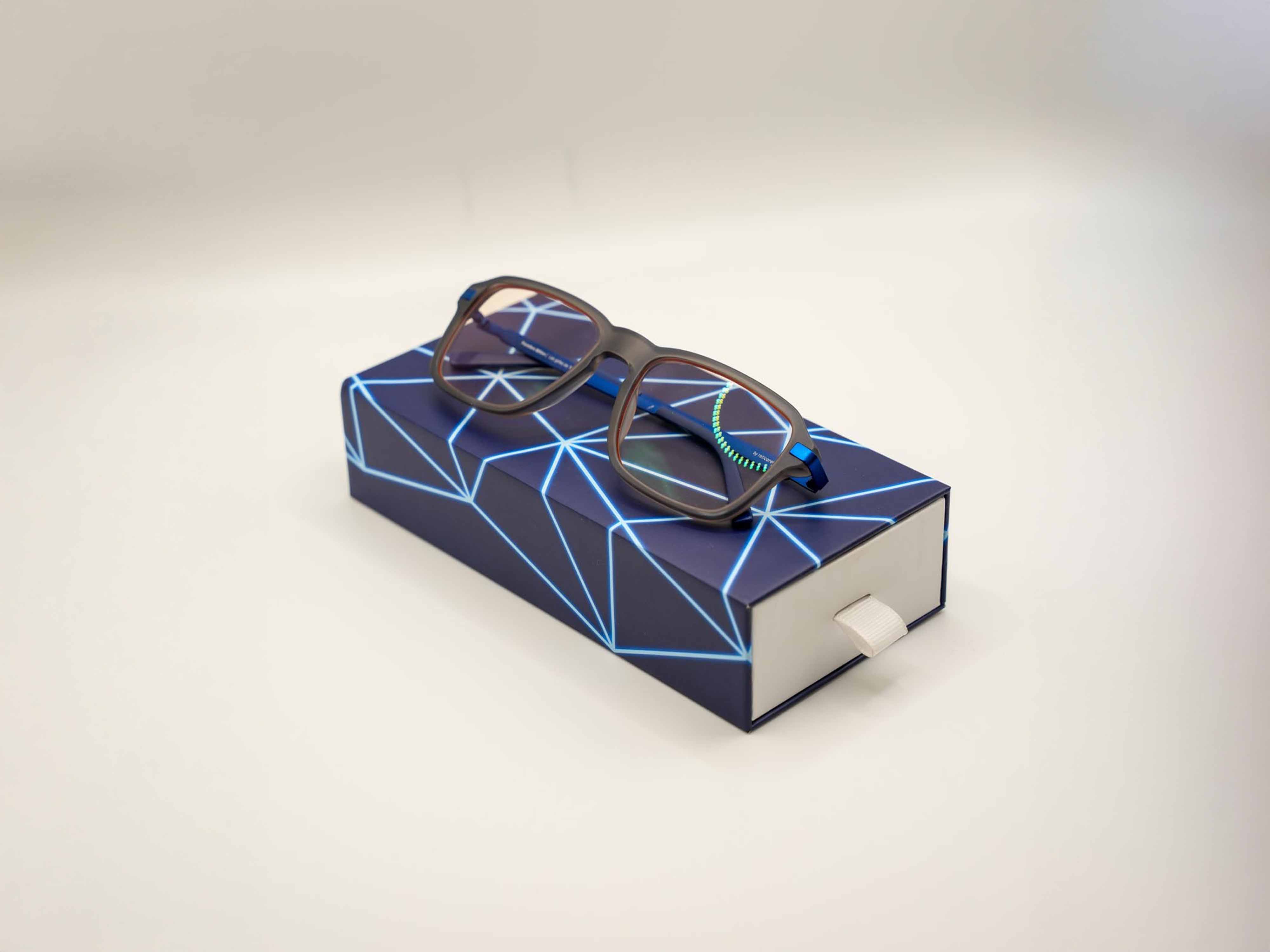 Determined woman walking on an outdoor running track, wearing a white cropped top with mesh sleeves and black track pants on a cloudy day.