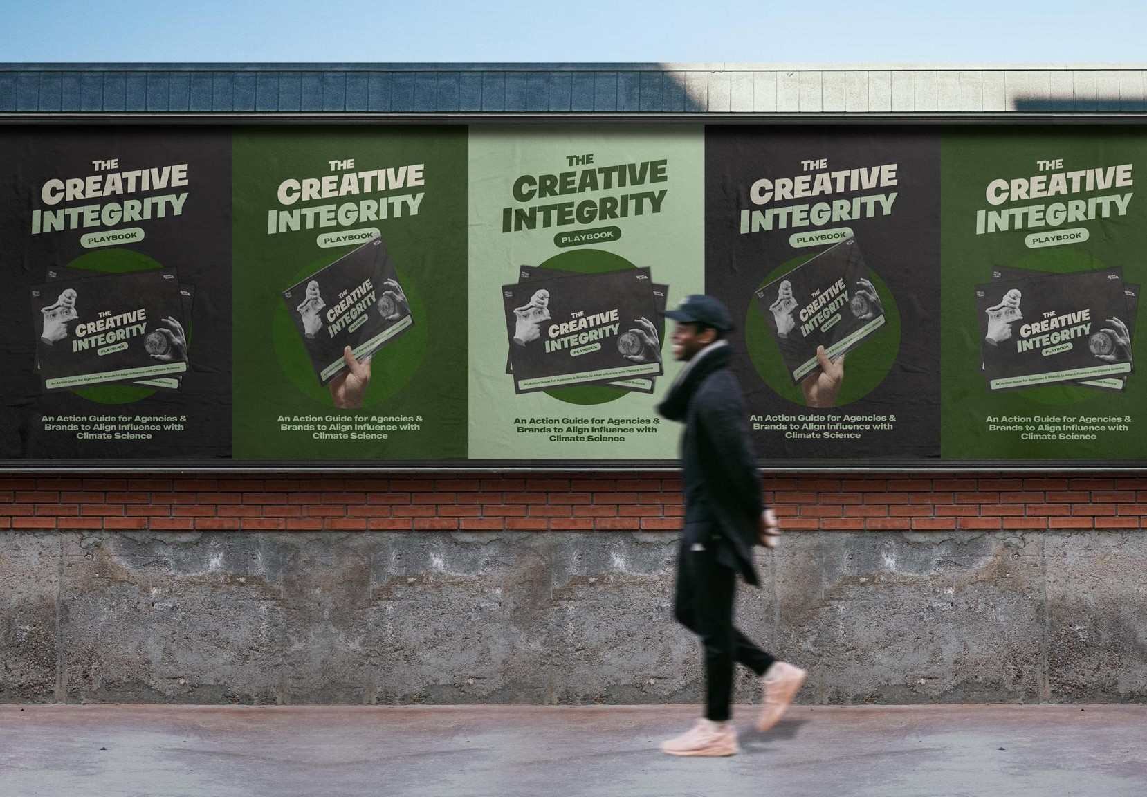 man walking past Billborard advertising the Creative Integrity Playbook by Creatives for Climate