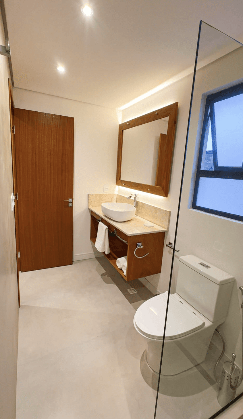 Evening shot of the suite, warm lighting throughout the space, subtle glows from pendant lights and table lamps.