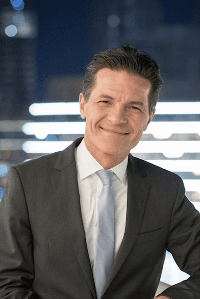 Portrait of Dr. Olivier Harnisch, founder of Lunasole Hospitality, wearing a suit and smiling in a professional setting | Lunasole Hospitality