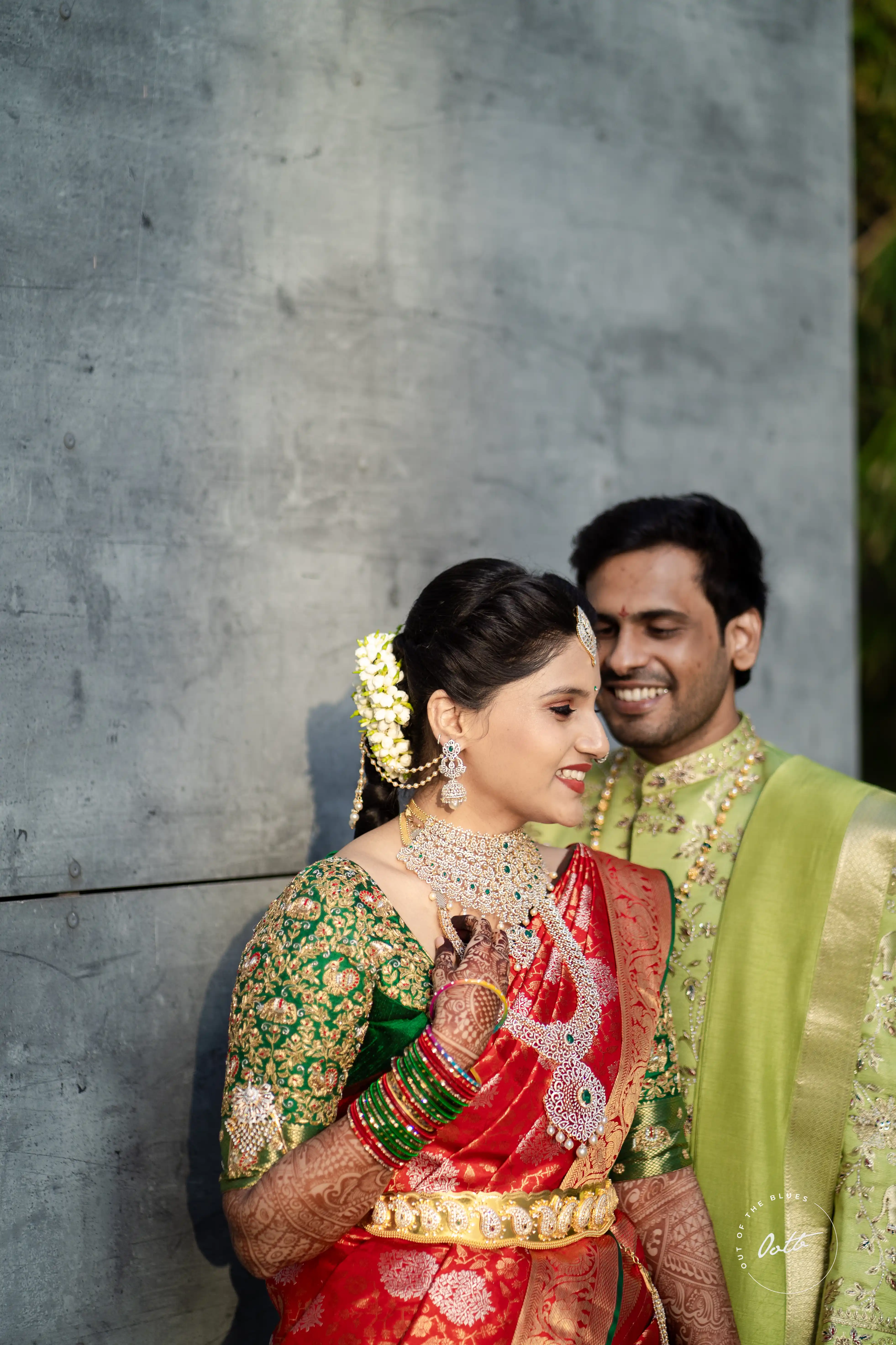 Tanya giggles while posing with Jashwanth smiling beside her. Captured by Out of The Blues Fine Art Wedding Photography in Hyderabad.