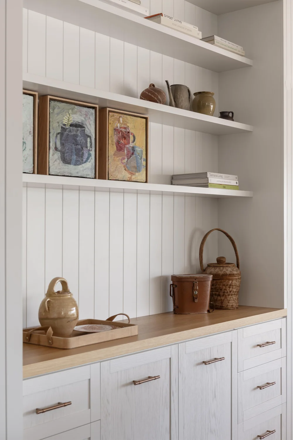 Custom shelving with artwork, ceramics, and timber joinery detail.