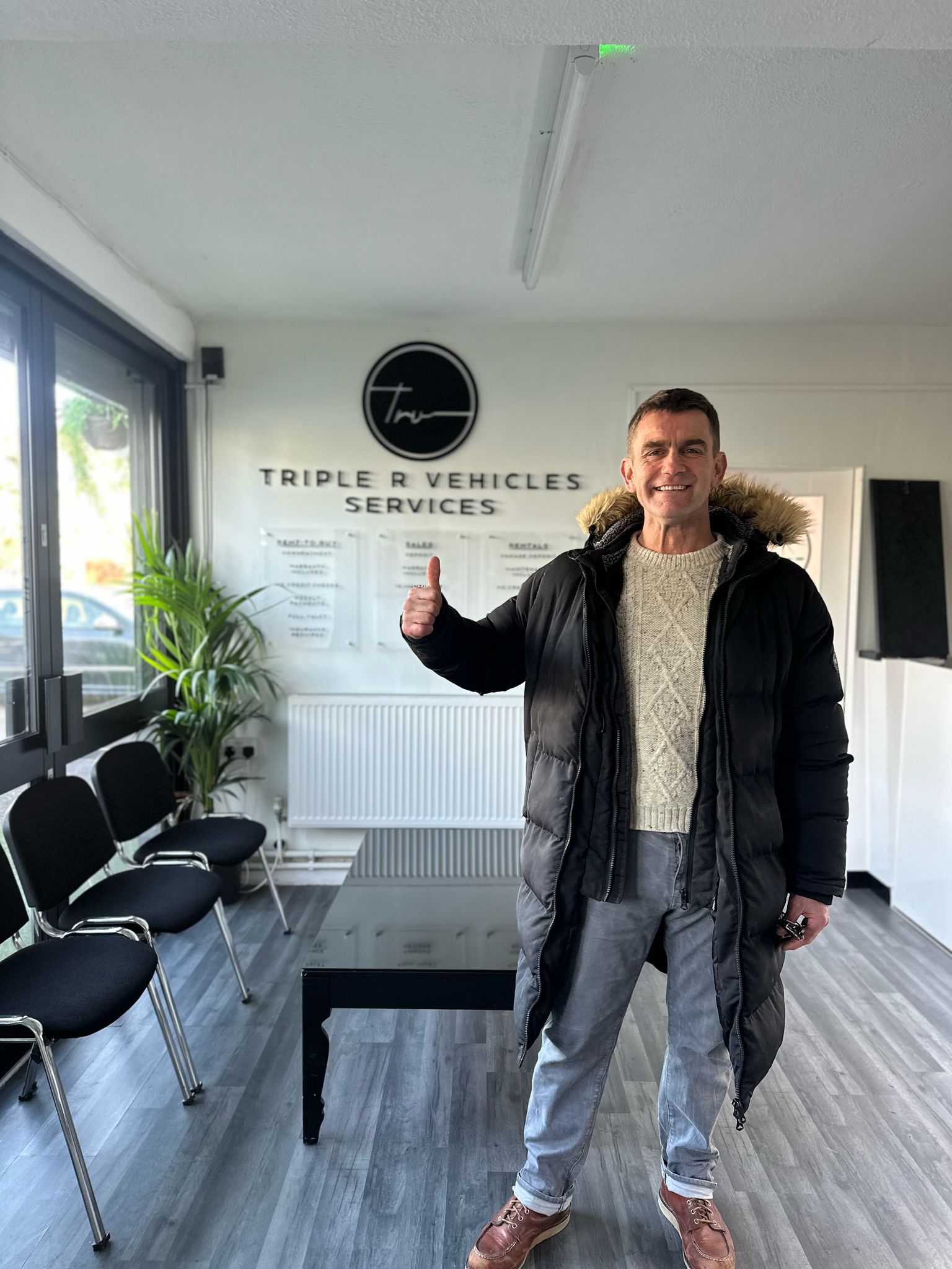 A smiling new vehicle owner sat in his new car.