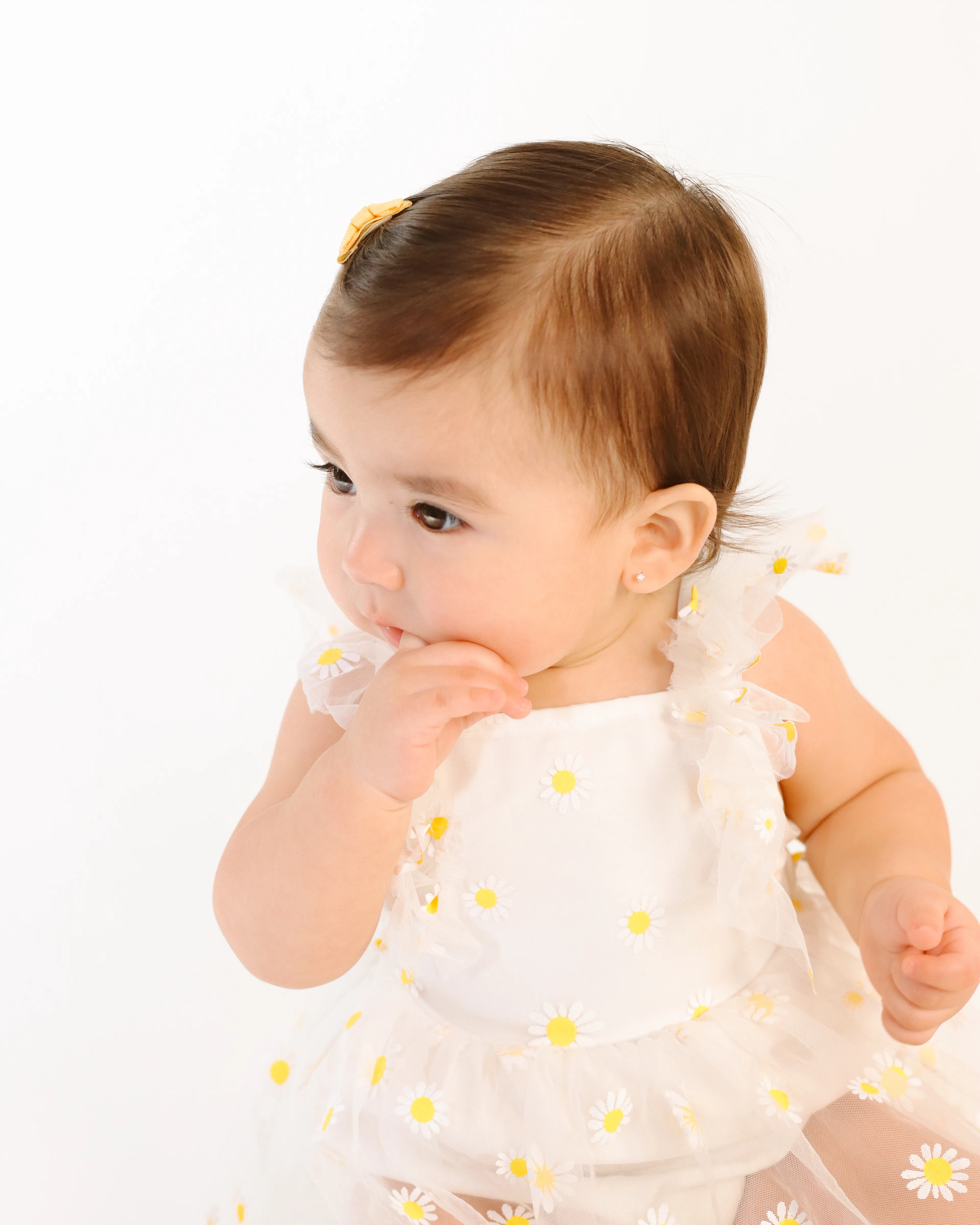Primer plano de bebé con vestido blanco de margaritas