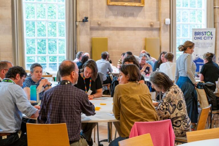 Photo of One City Gathering with people sat a tables in groups