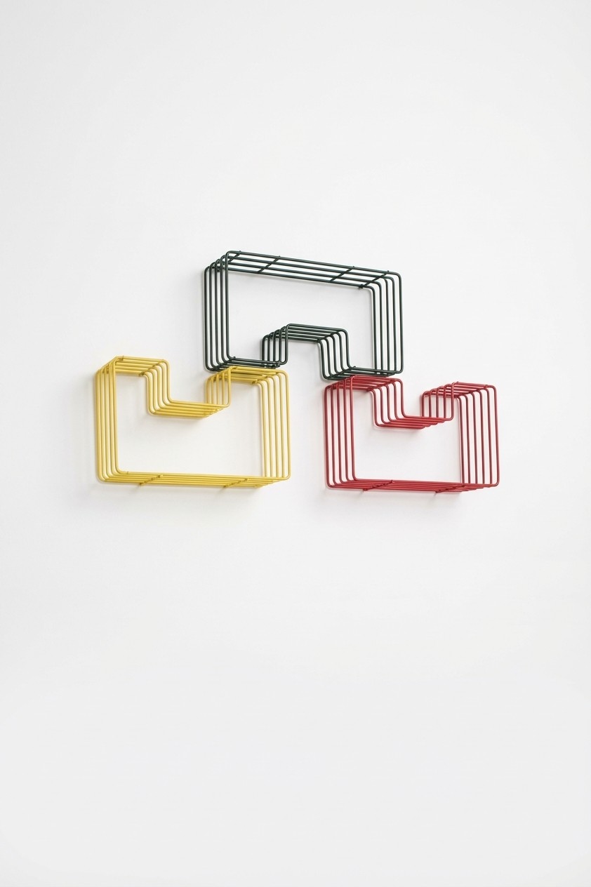 Minimal studio portrait of a confident woman in a white shirt, arms crossed, on a soft gray background.