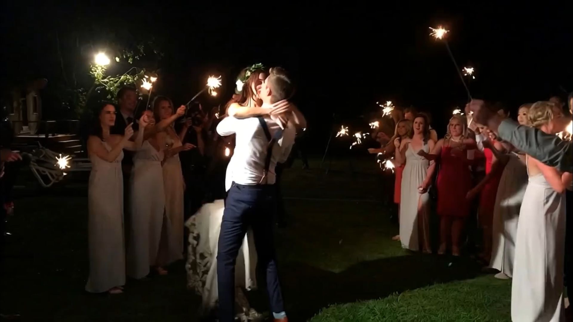 Wedding couple dance togher outdoors with their friend and family.