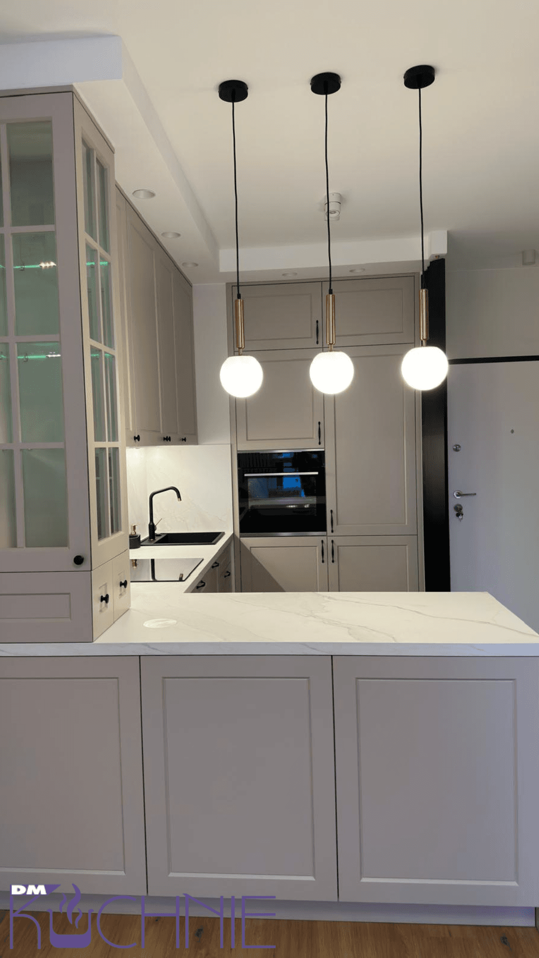Kuchnia z wyspą i oświetleniem wiszącym, fragment realizacji mebli na wymiar